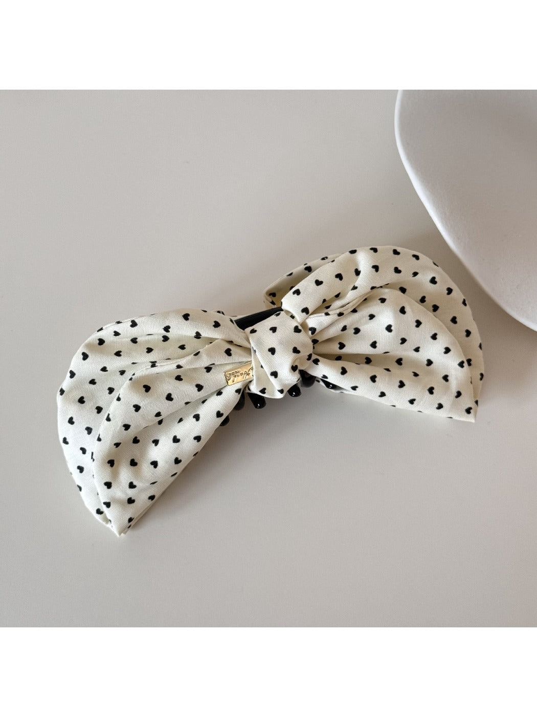 Beau elegant bow banana clip displayed on a flat surface, bow facing up