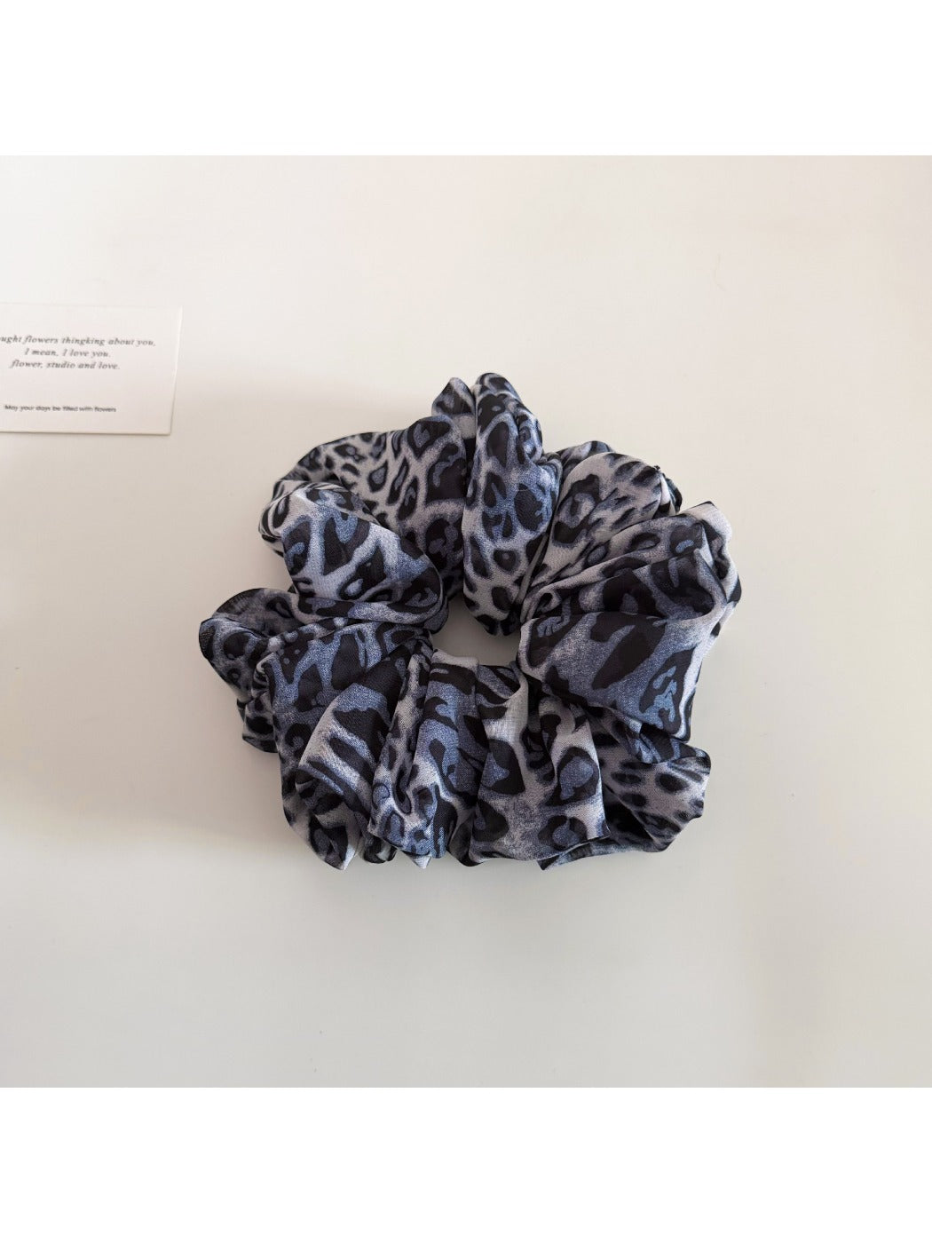 Detailed view of fabric pattern and texture on vintage leopard scrunchie