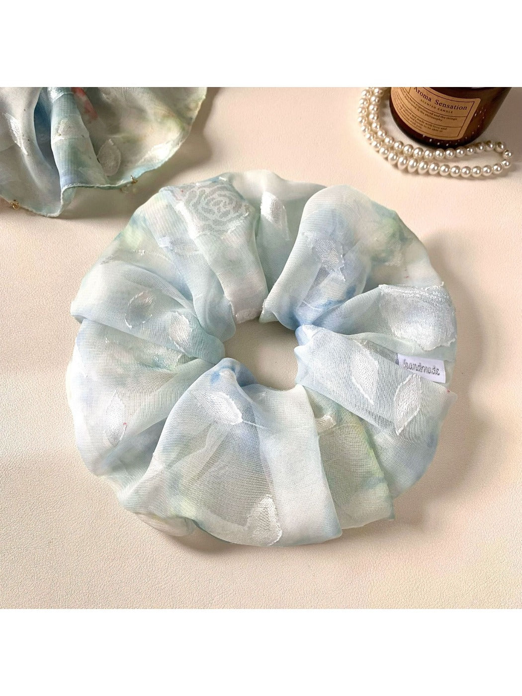 Gifty natural pure blue scrunchie styled in a ponytail on a model