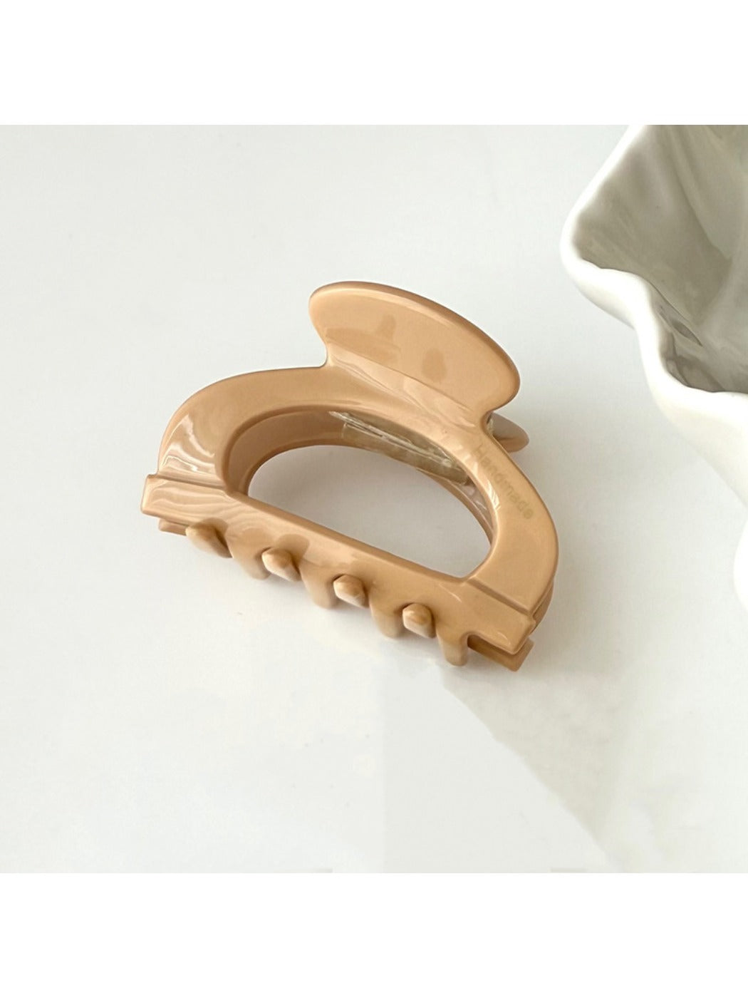 Beau claw clip in use holding hair, showcasing its semi circular shape and openwork style