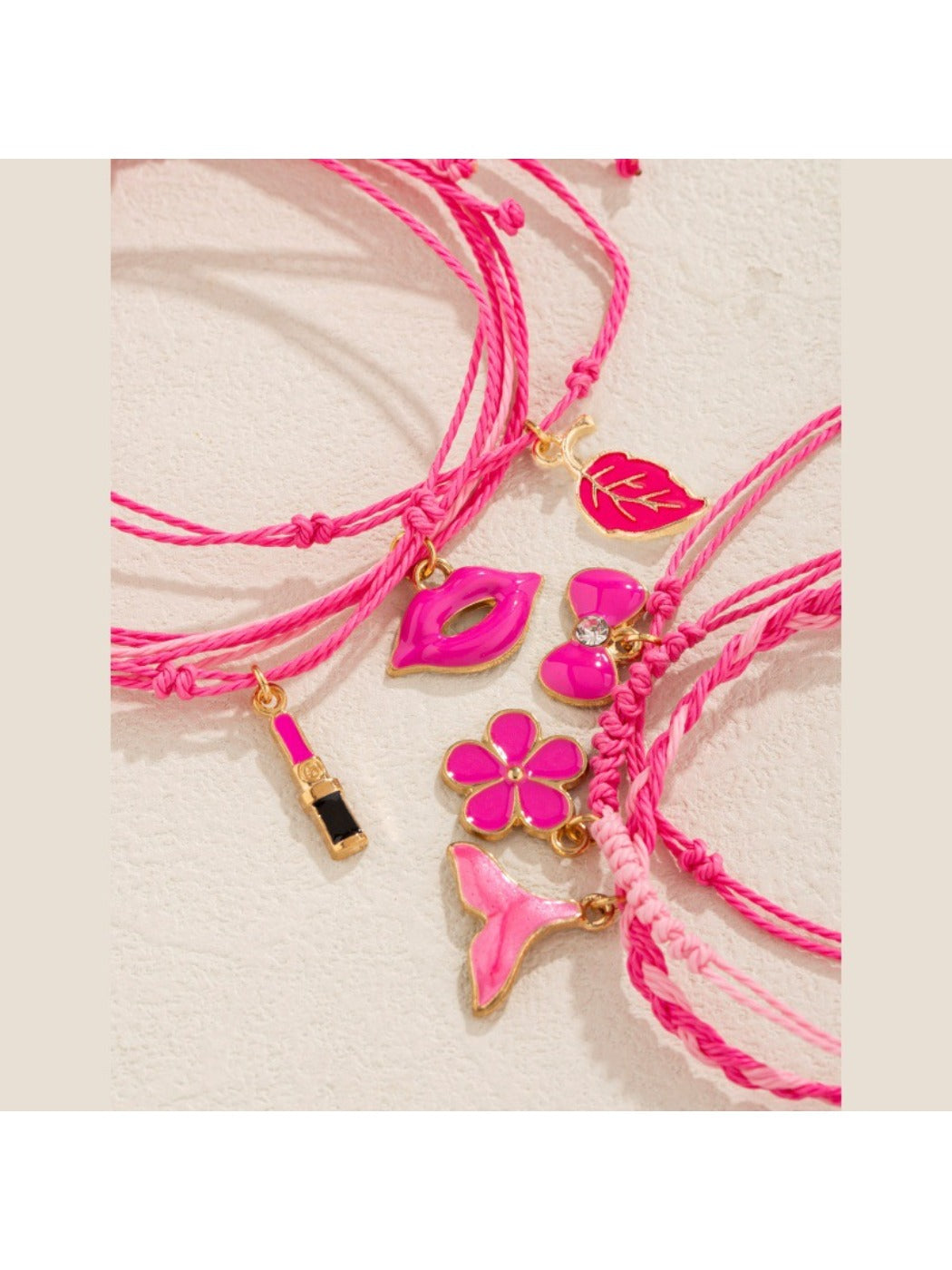 Close-up of lipstick bow-shaped pendant on Lovra woven bracelet