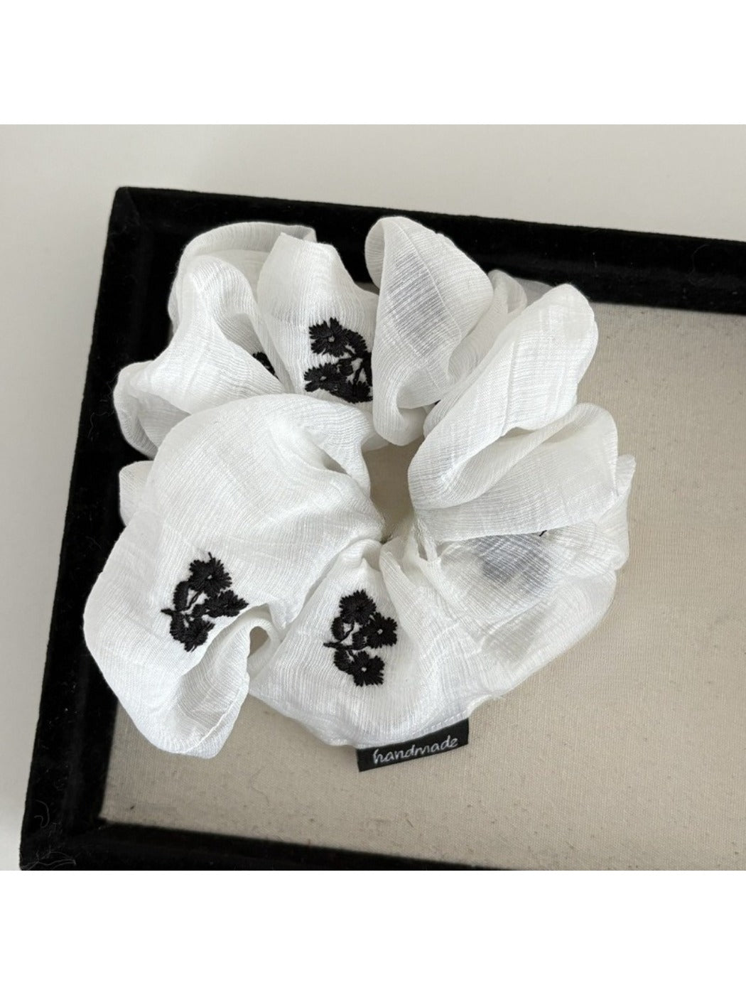 Gifty scrunchie styled in hair, featuring simple gentle floral print