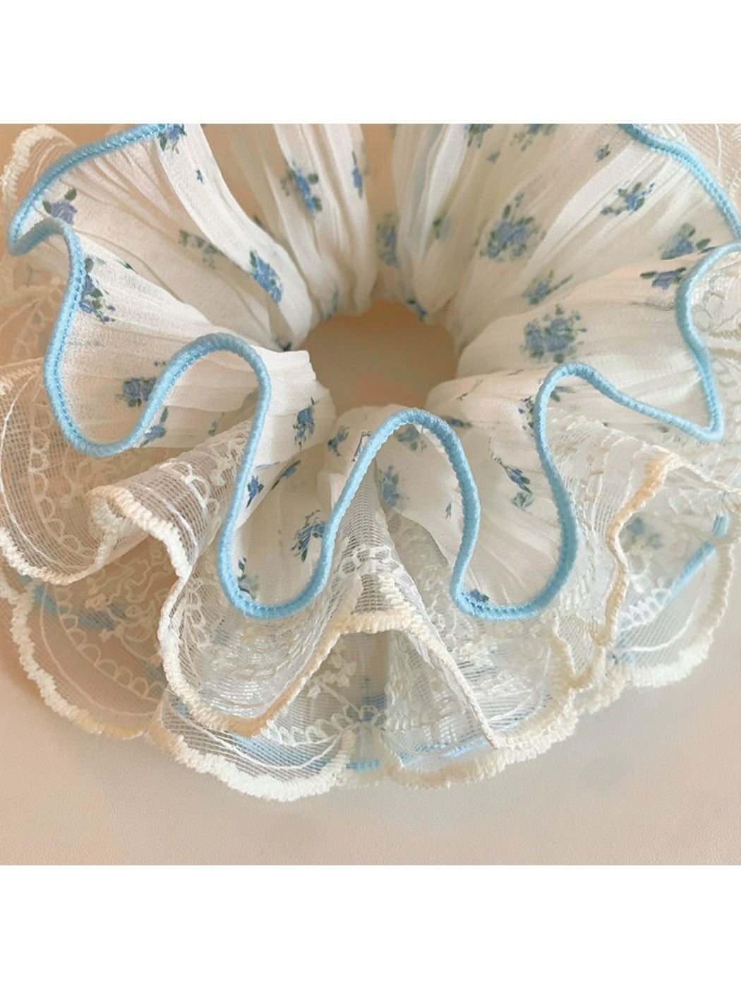Gifty sweet floral ruffled scrunchie displayed flat highlighting ruffled edges and floral design