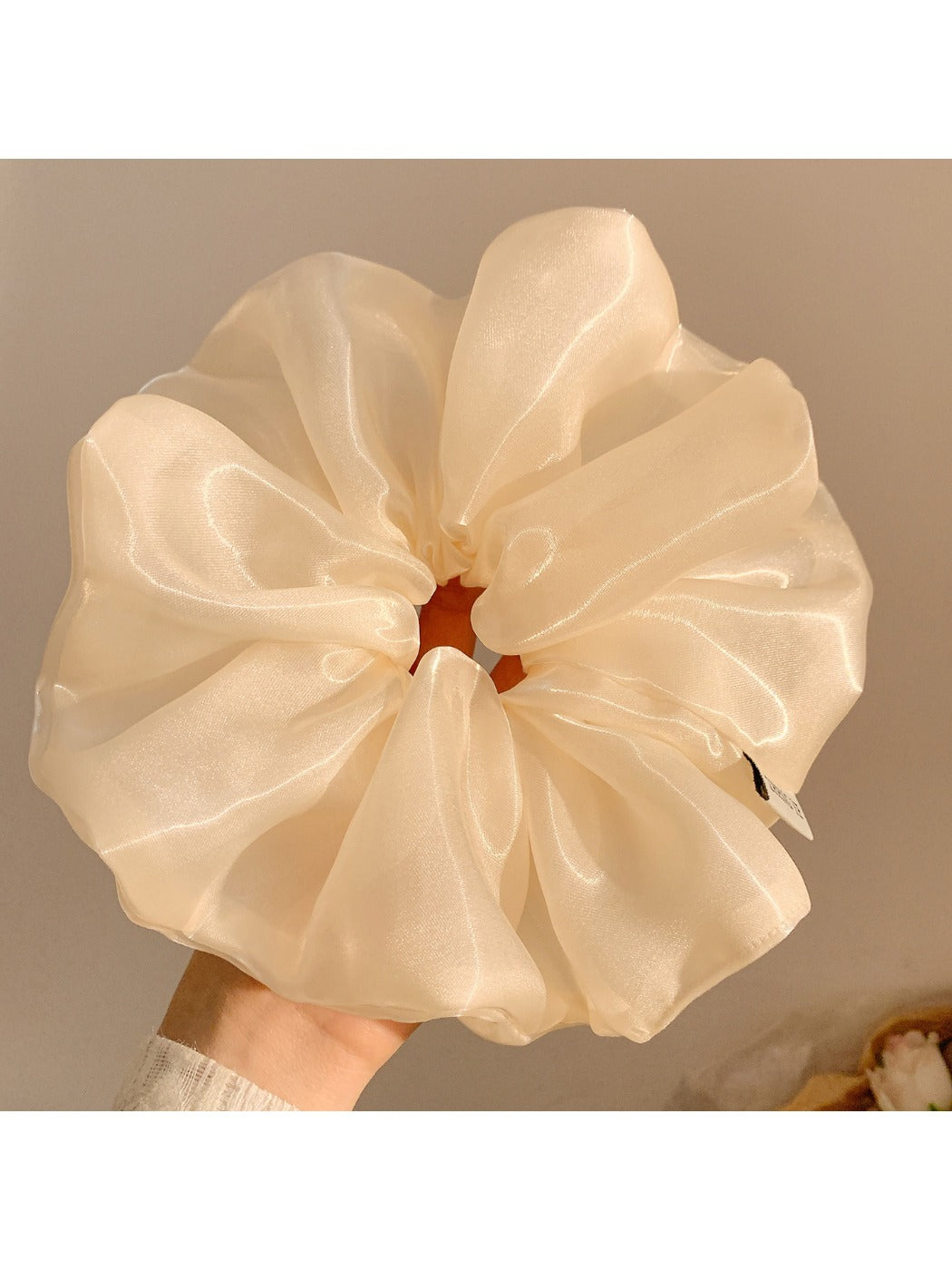 Gifty minimalist shiny scrunchie worn in a ponytail on dark hair