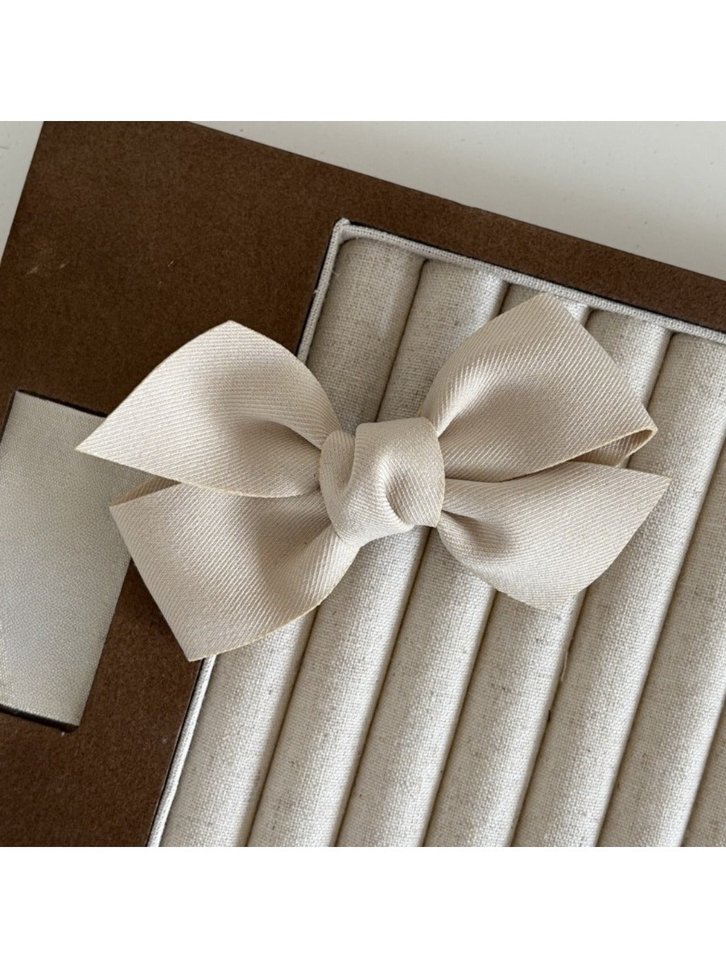 Beau satin bow hair clip photographed with soft natural lighting
