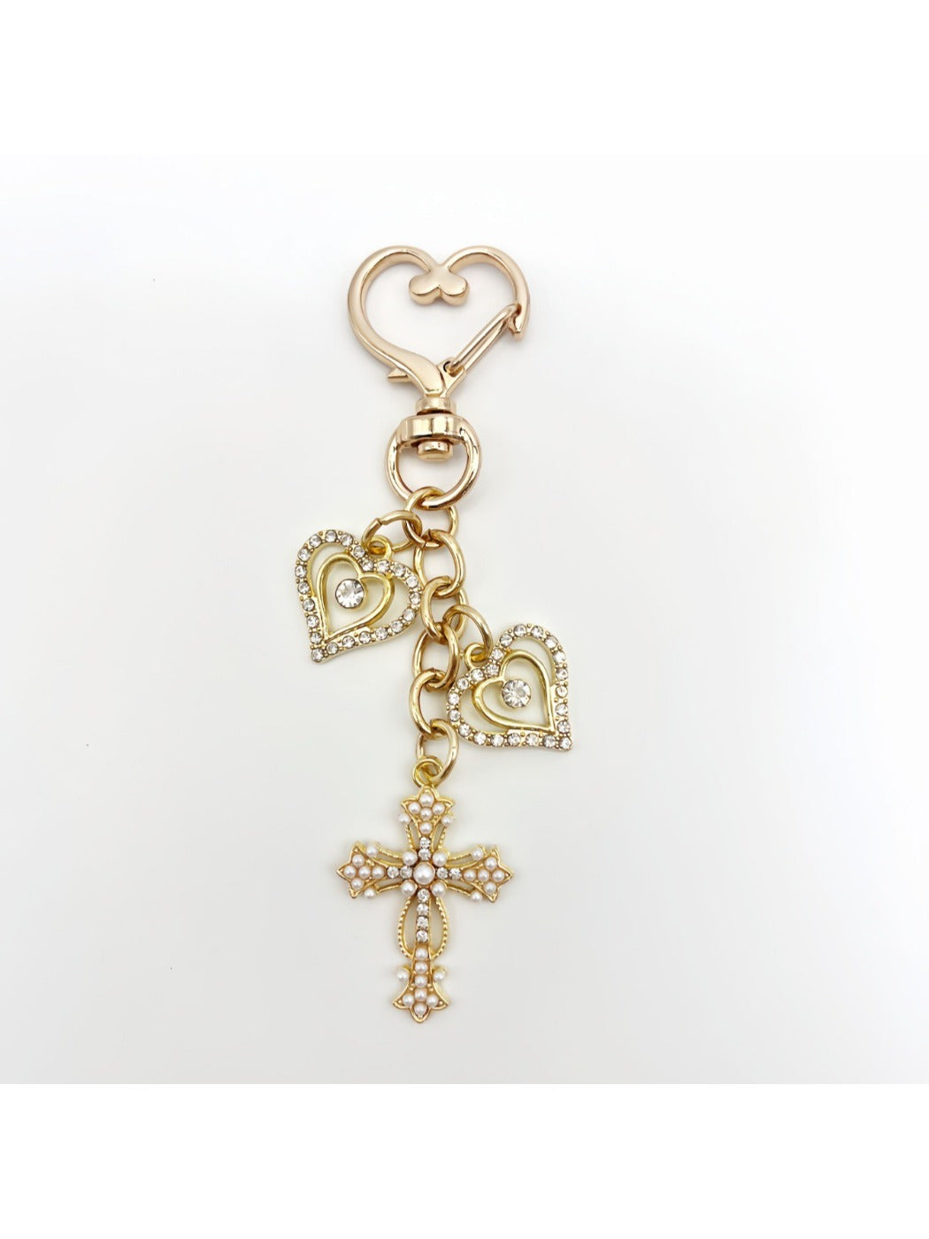 Vintage cross pendant keychain resting on a fabric background