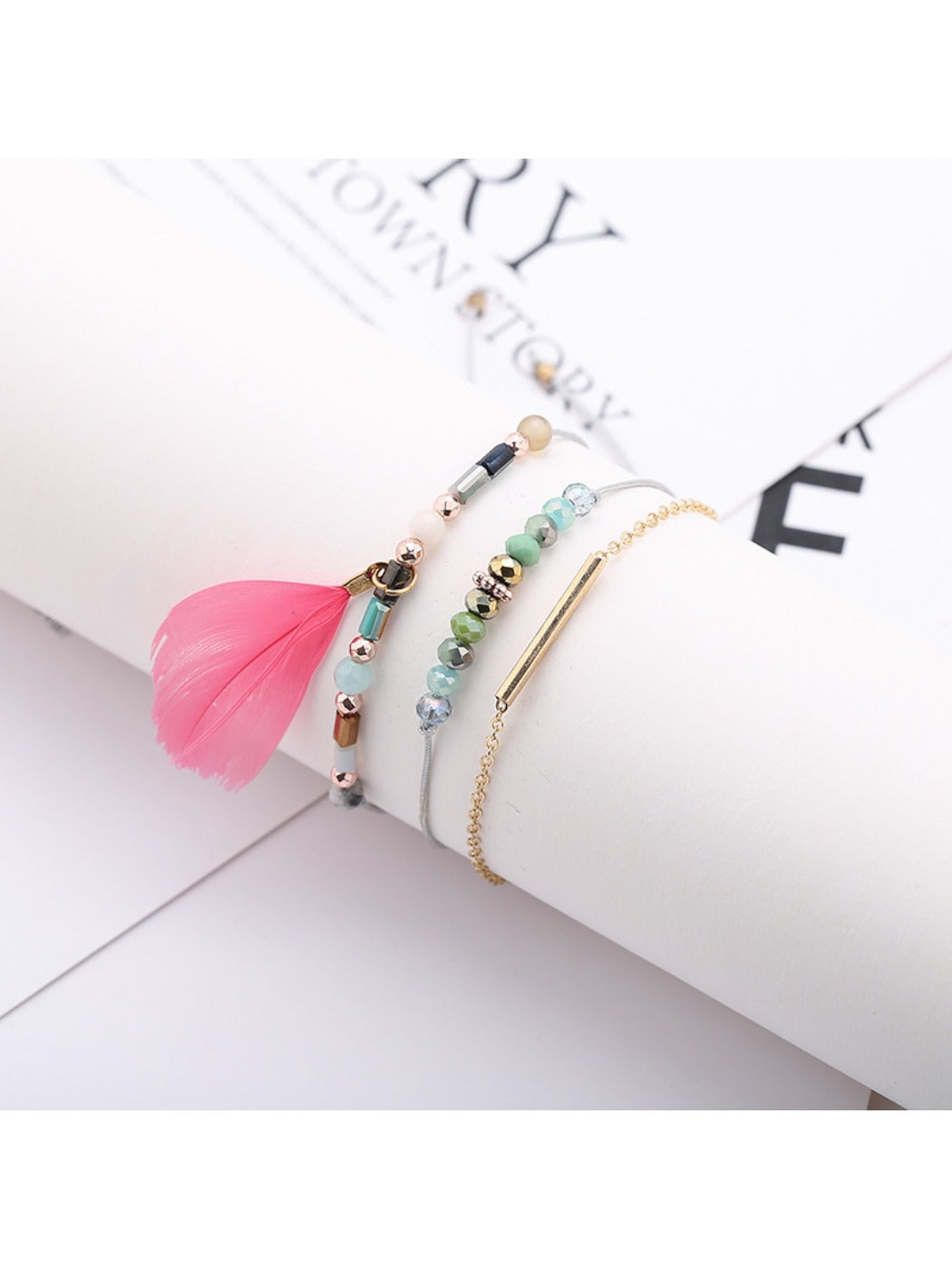 Lovra feather pendant bracelet displayed alongside matching jewelry pieces