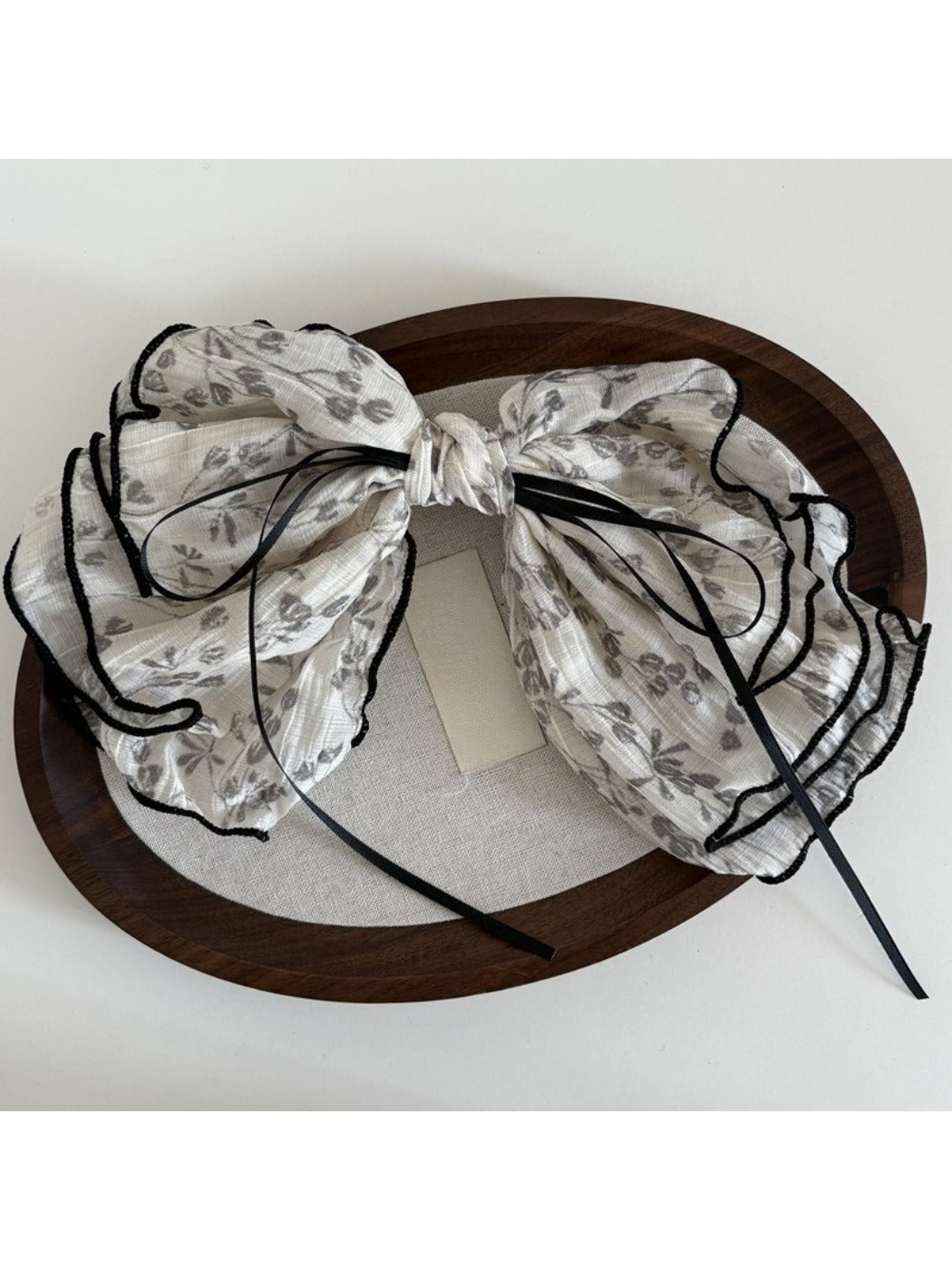 Beau floral bow hair clip styled in hair, showcasing its decorative floral design