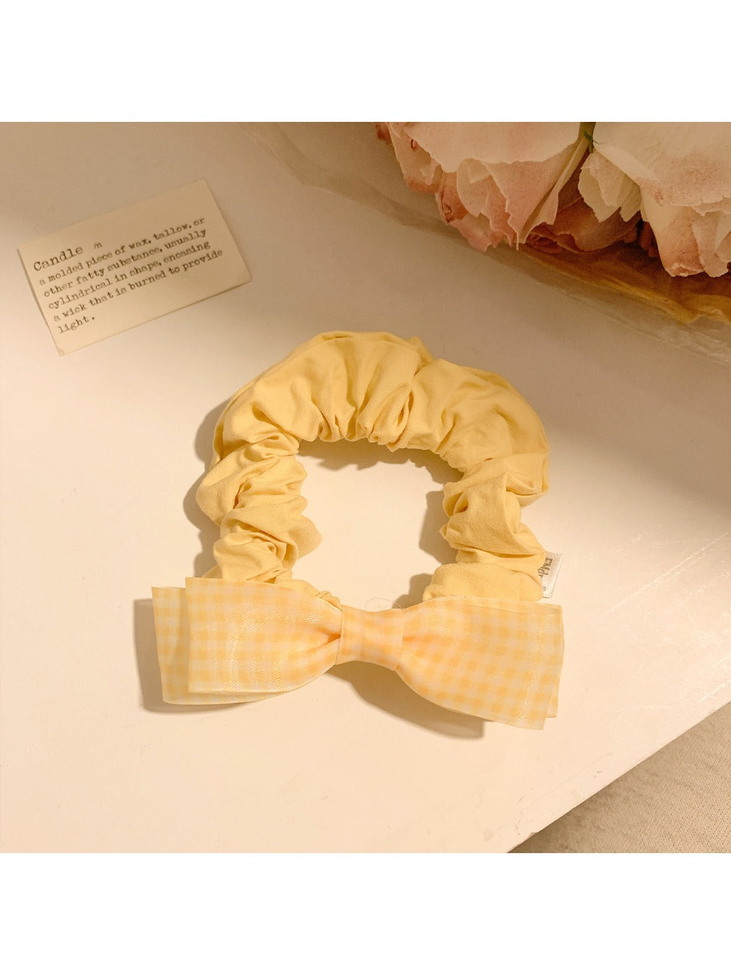 Gifty hair tie with pink bow worn on a model's wrist