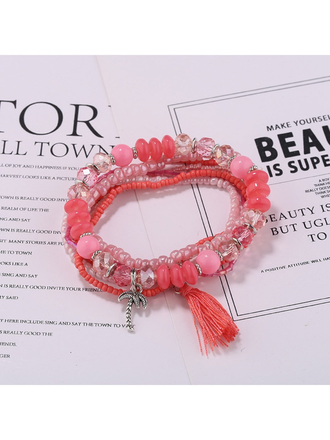 Lovra multi-row beaded bracelet with tassels on a rustic wooden surface