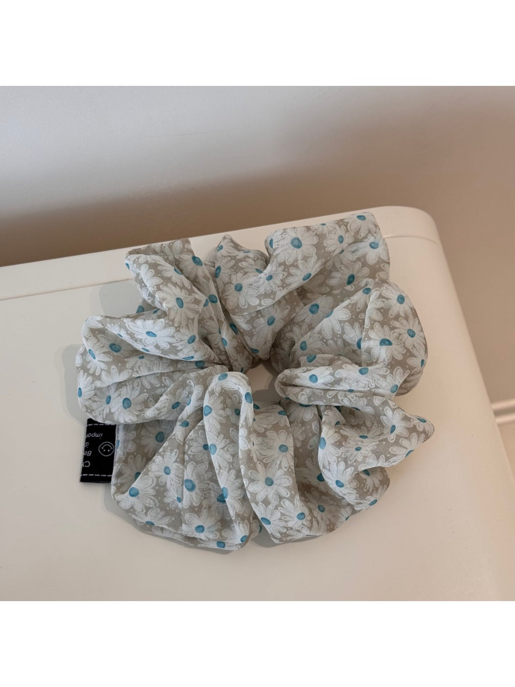 Gifty elegant daisy print scrunchie packaged in a clear plastic box