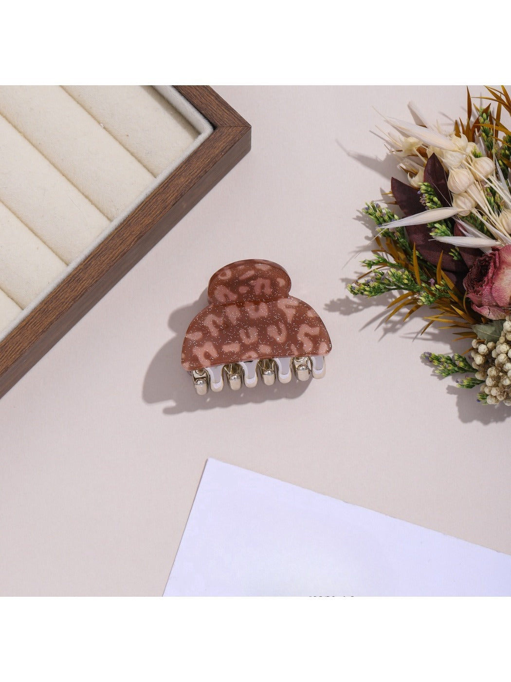 Beau leopard print hair clip shown in packaging with brand label
