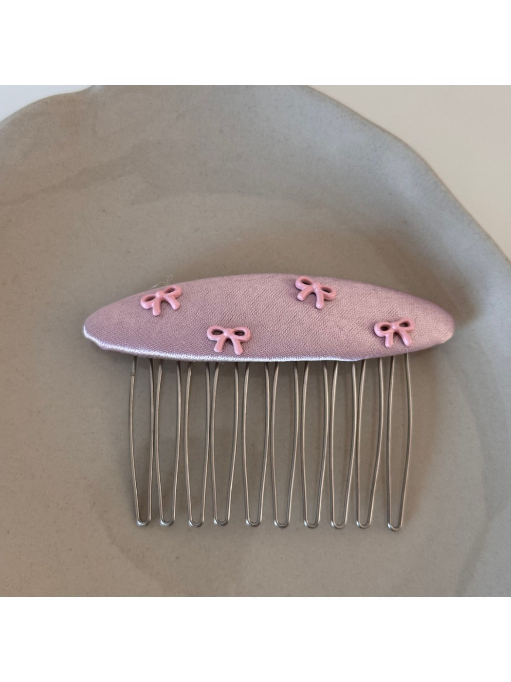Pink bow hair clip styled in a half-up hairstyle on a model