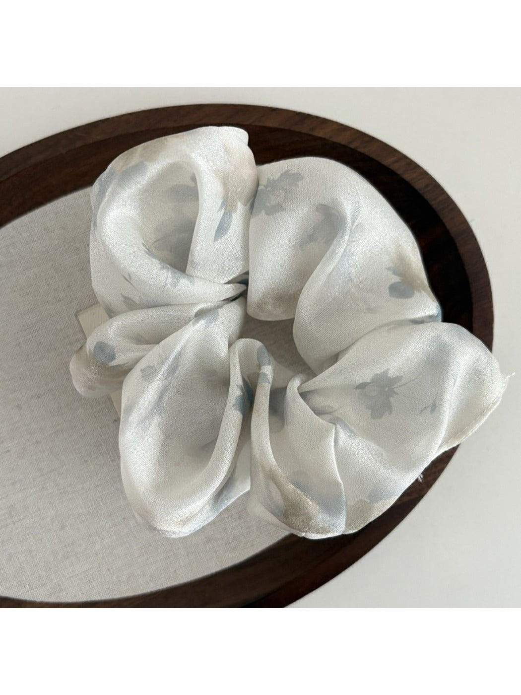 Gifty printed satin hair scrunchie on a neutral background showing elastic stretch