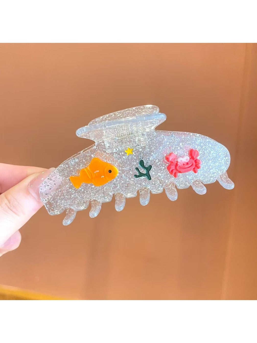 Beau fish decor claw clip held in hand showing size and detail