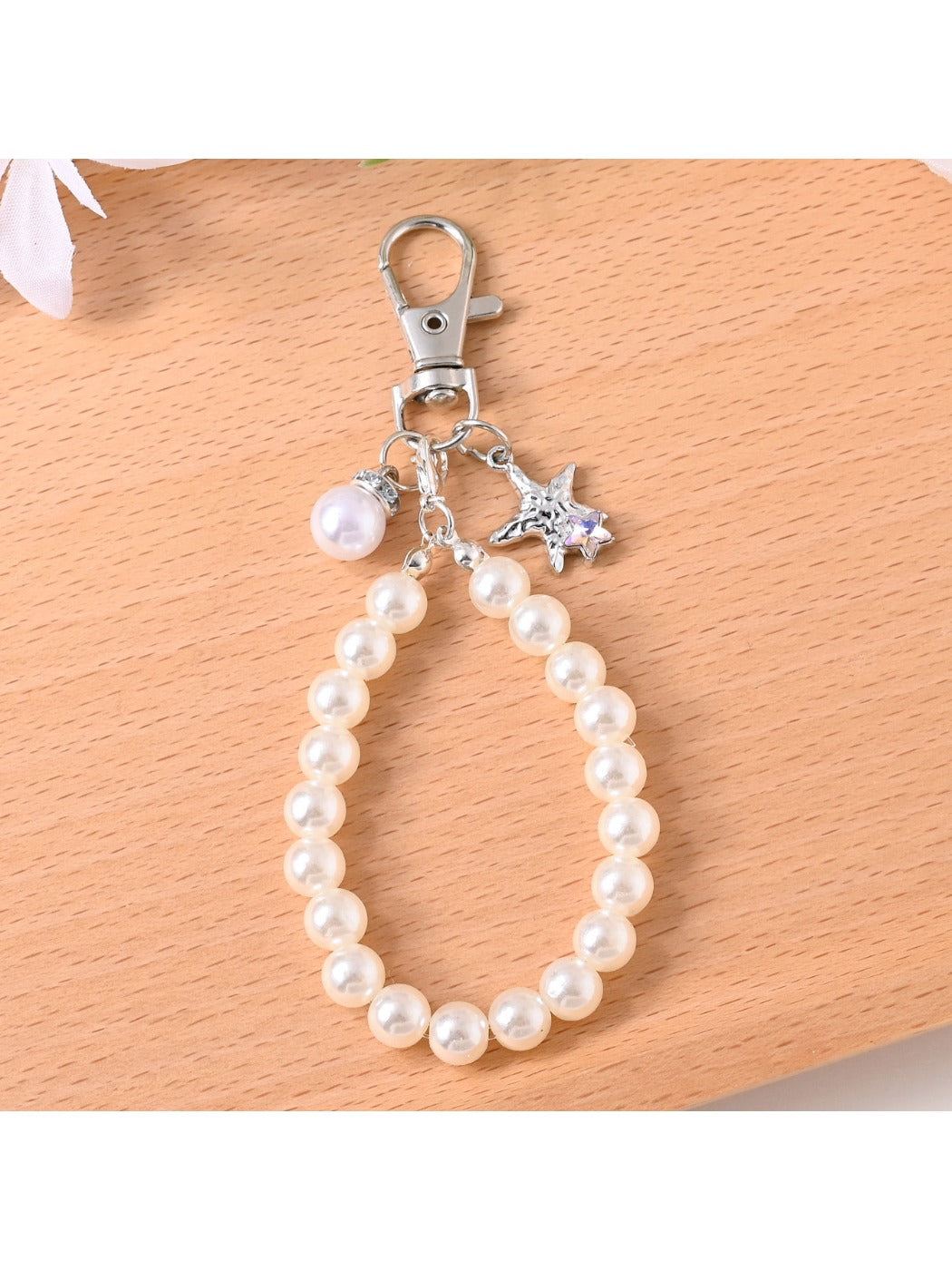 Hand holding Keypus beaded bag charm keychain showing its size and details
