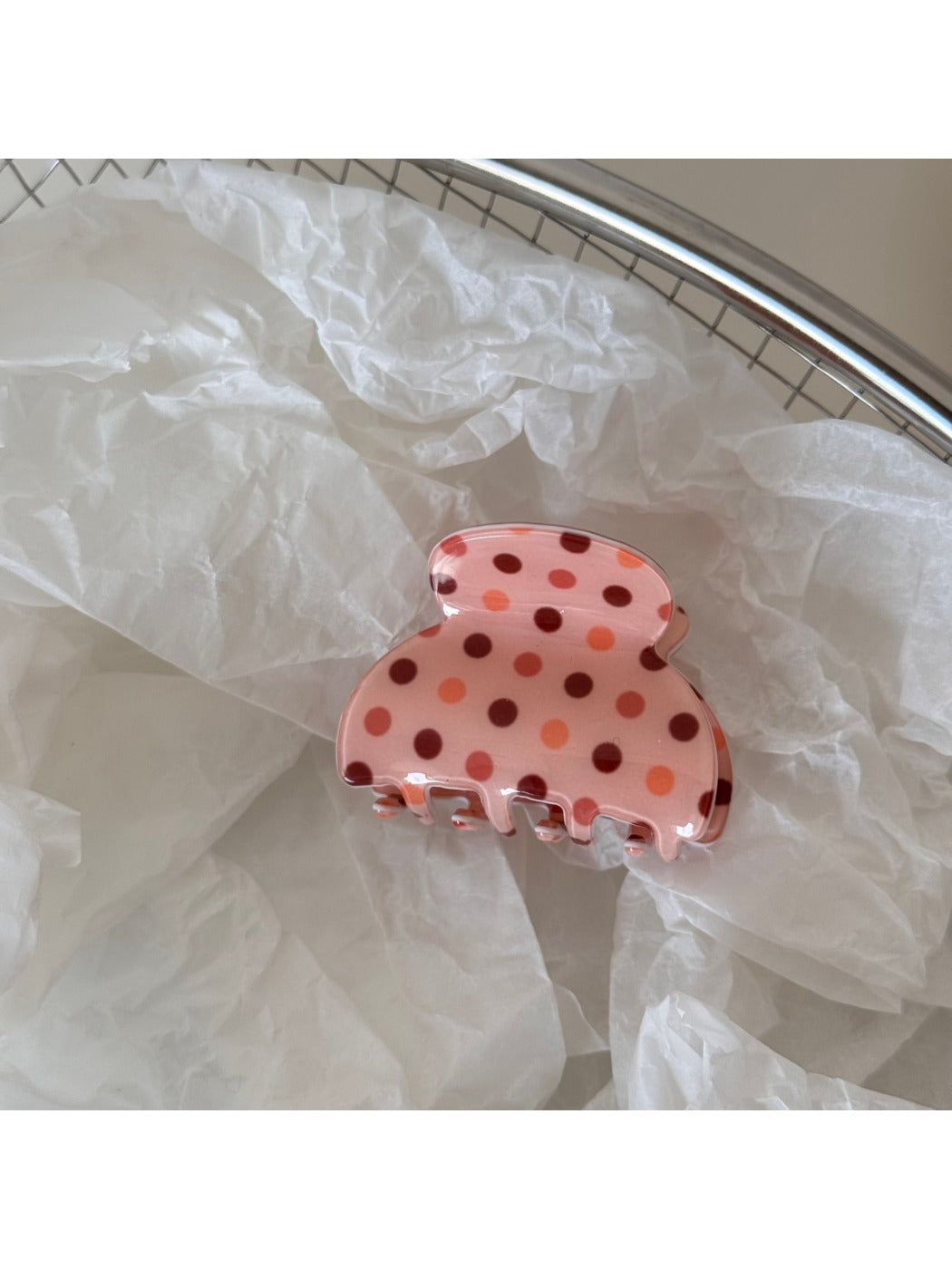 Beau pink polka dot hair clip photographed with soft natural lighting