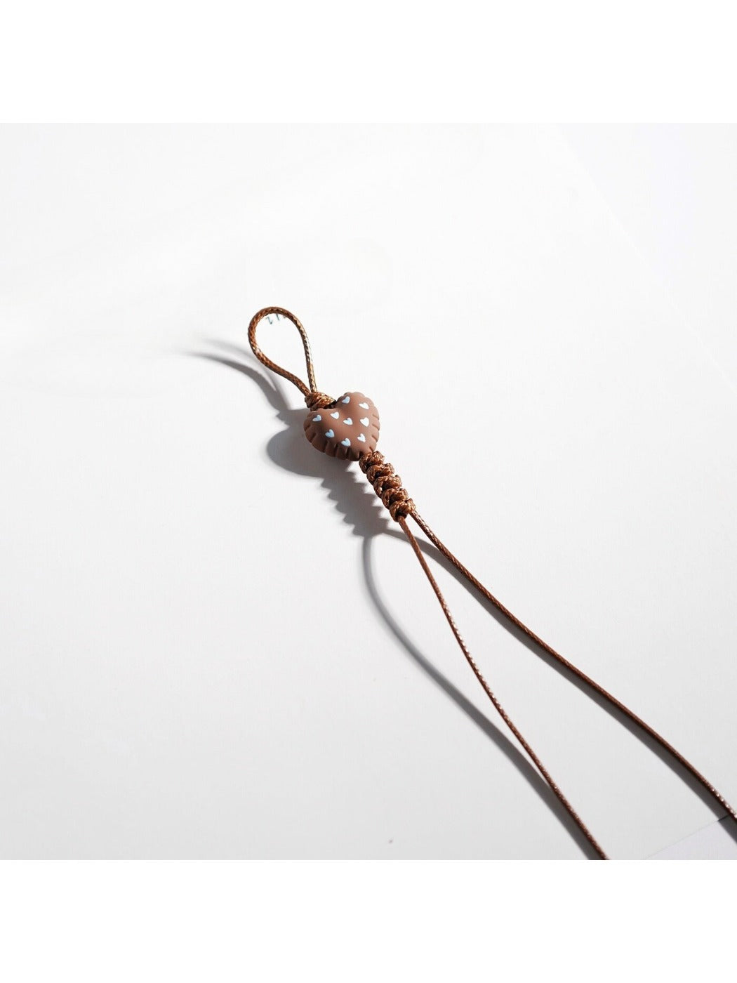 Brown tone cartoon keychain hanging on a hook in a retail setting