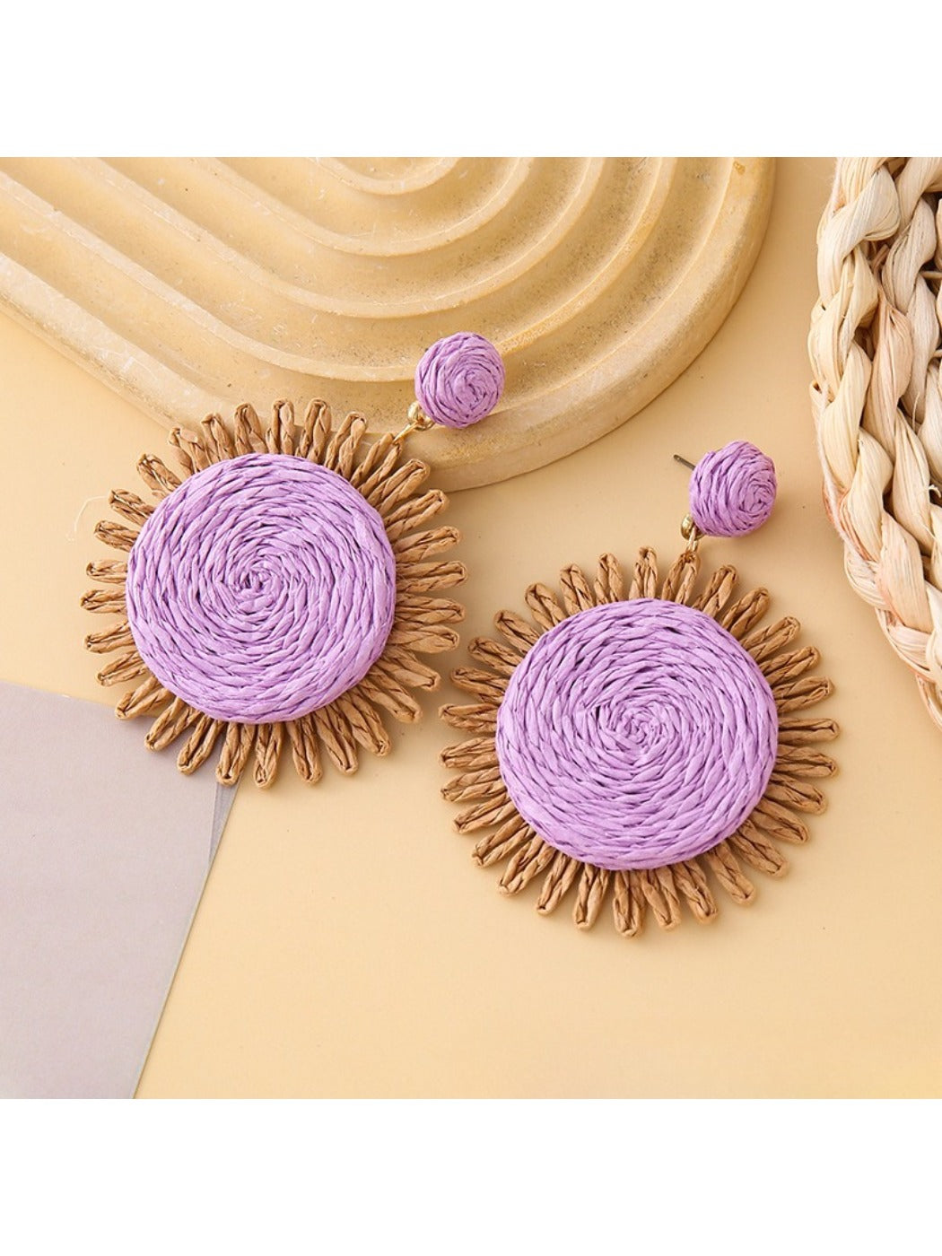 Detailed shot of colorful raffia earrings showing natural fiber material