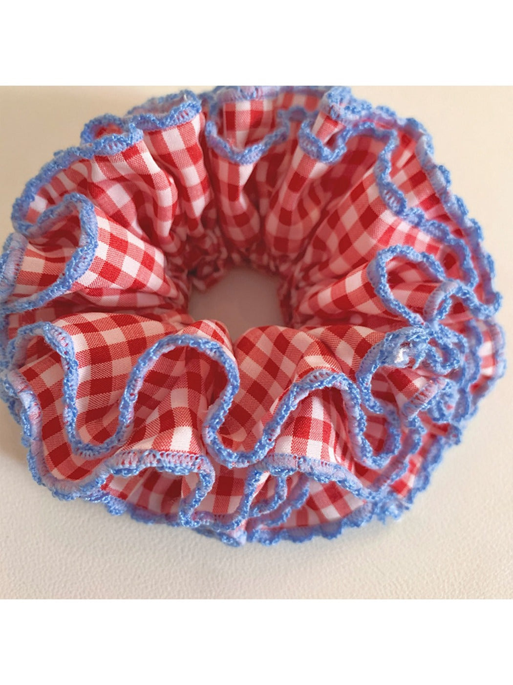 Red plaid scrunchie styled on a wrist as a fashion accessory