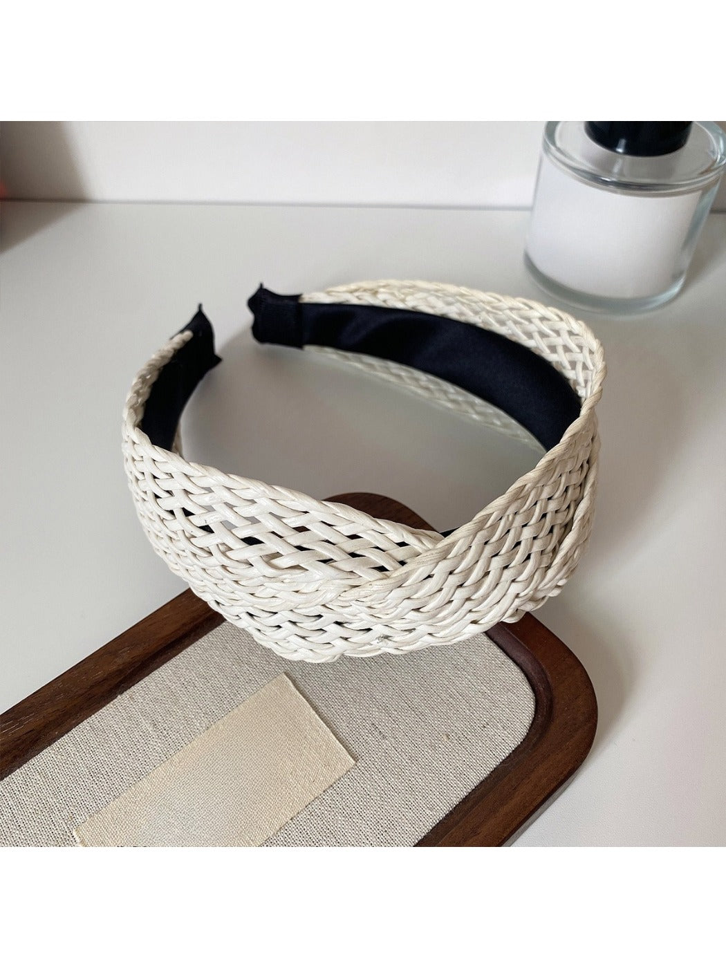 Model adjusting the Gifty wide crisscross headband in natural light