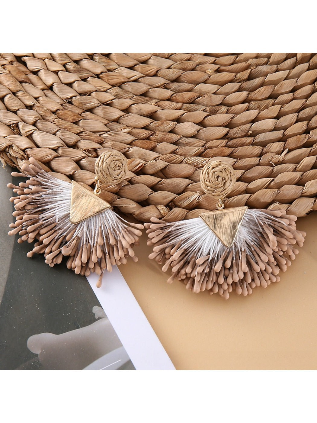 Close-up of earedge fan-shaped raffia earrings highlighting intricate weaving details