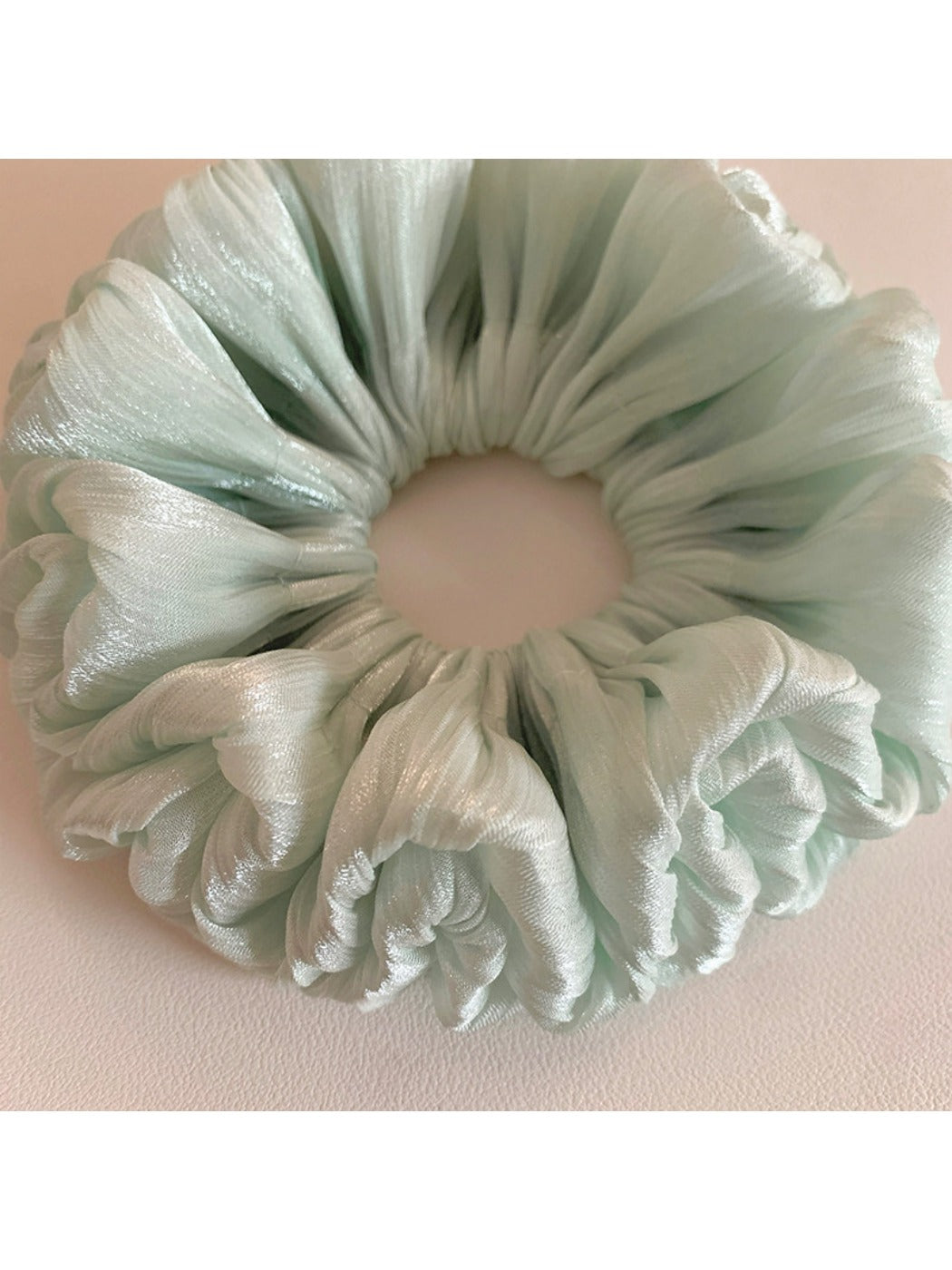 Green double layered scrunchie displayed on a white background