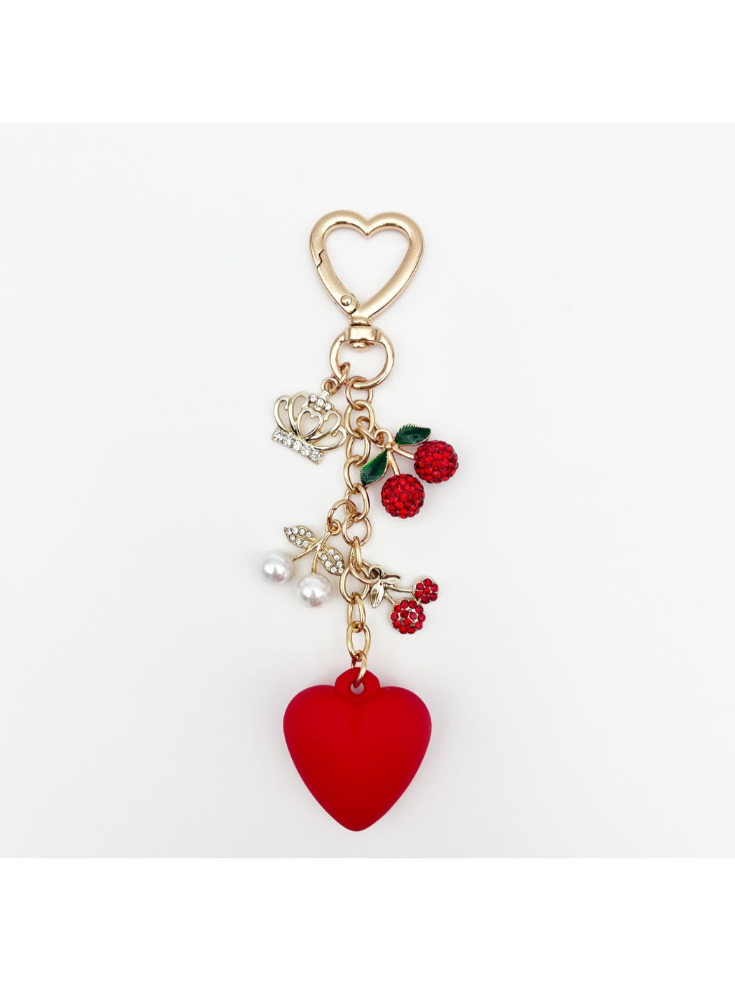 Cherry heart charm keychain held in hand showing size and detail of the charm
