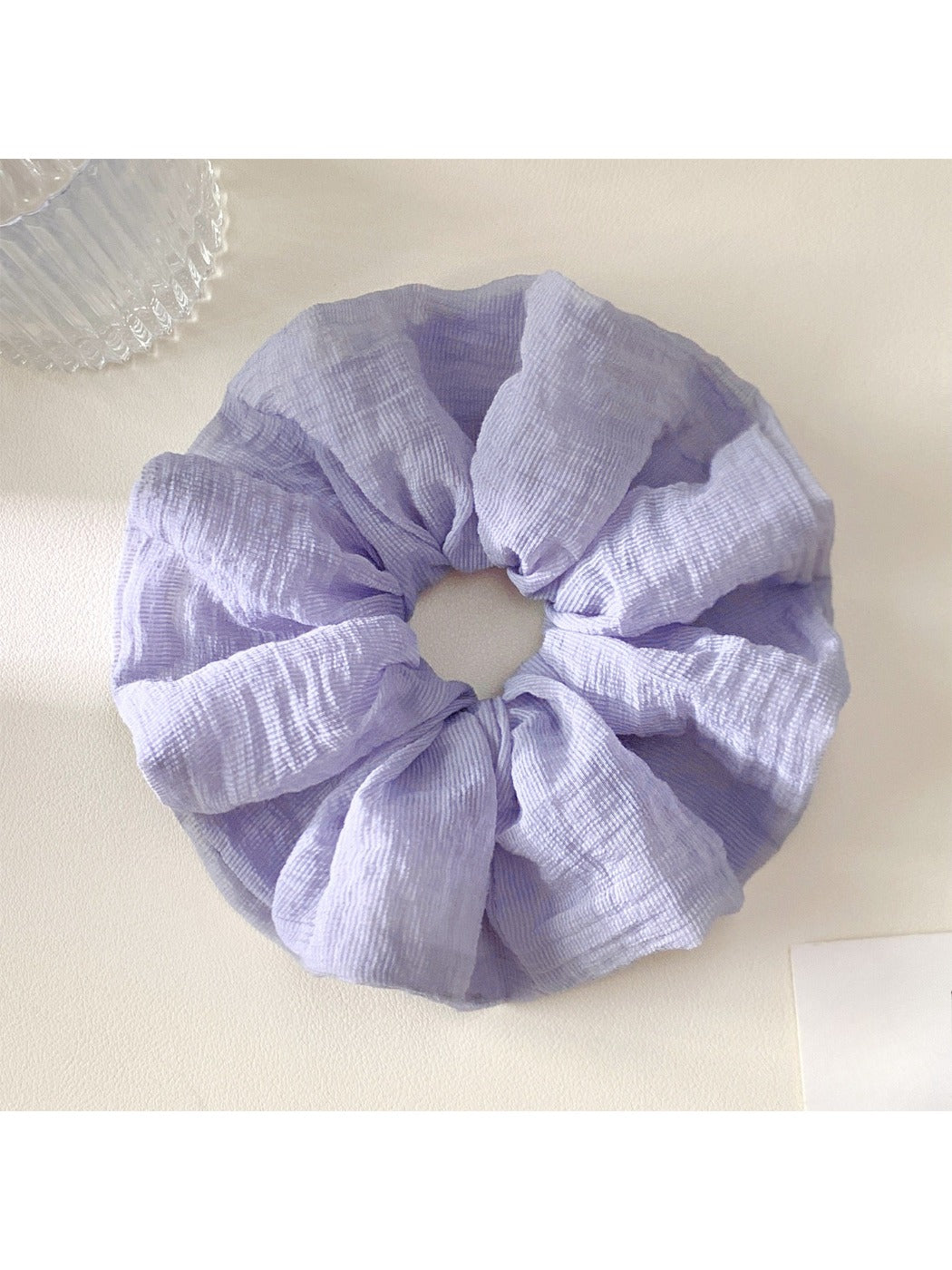 Scrunchie wrapped around a ponytail, showcasing its vibrant colors and soft fabric