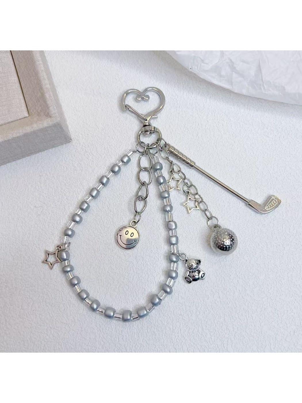 Golf ball charm keychain hanging from a set of keys on wooden surface