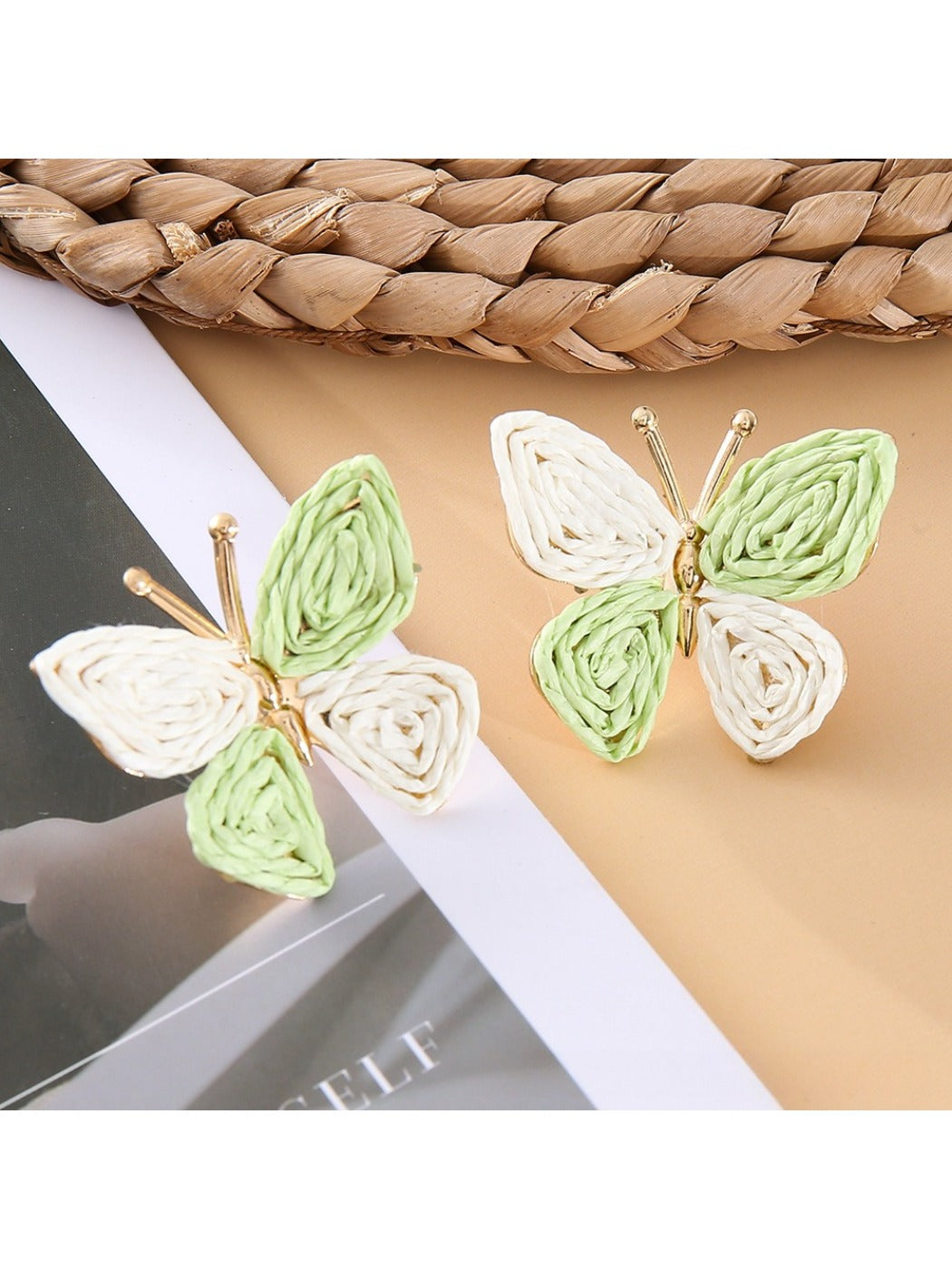 Butterfly drop earrings displayed with matching silver necklace on a white surface