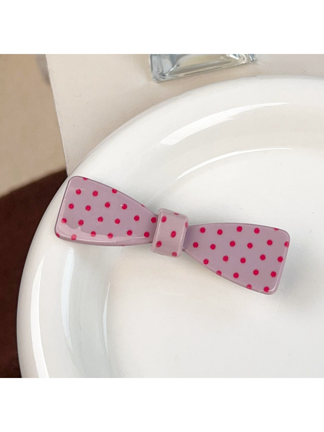 Beau sweet pink hair claw clip with white polka dots against a pastel background