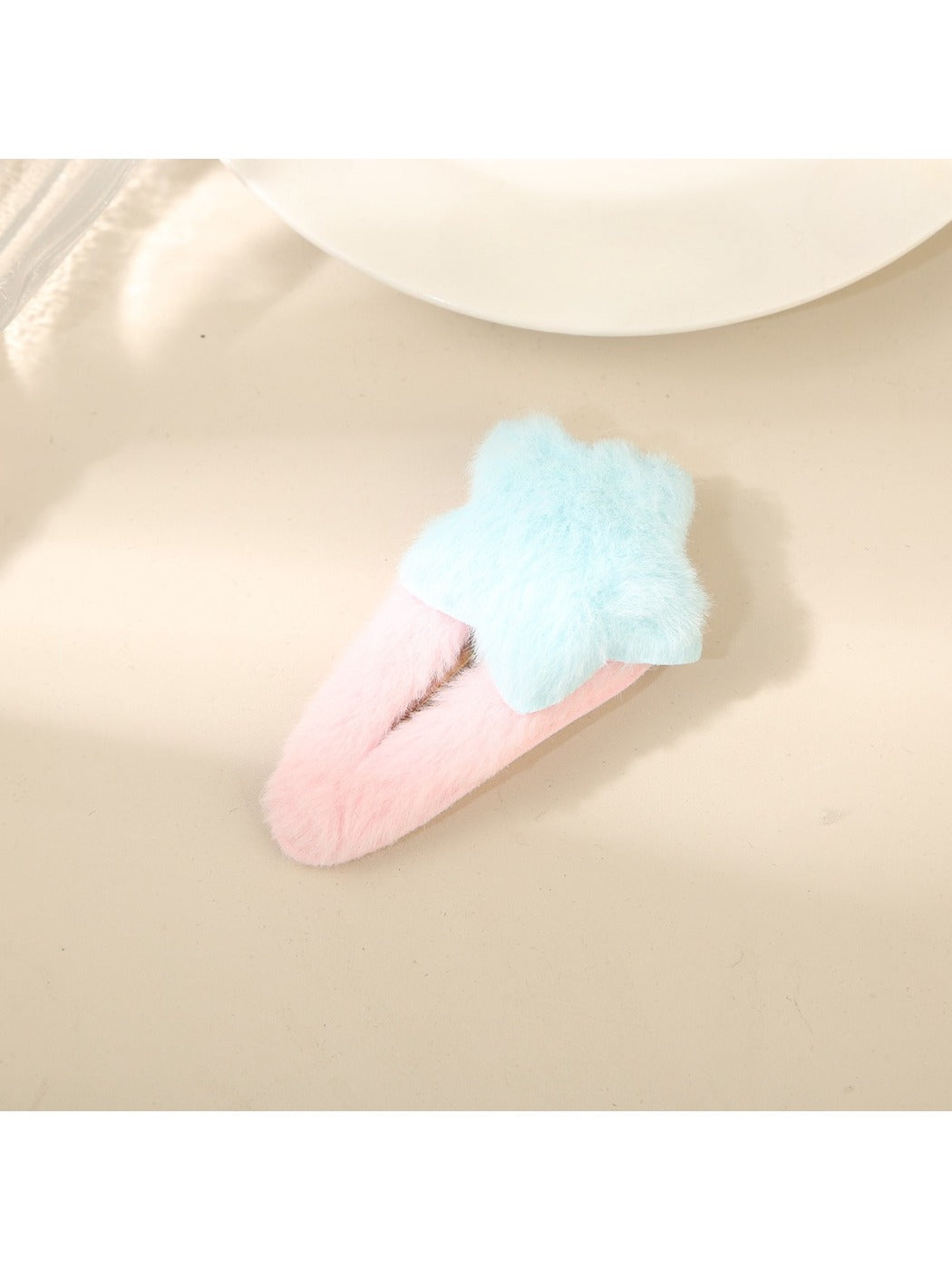 Beau fluffy star hair clip held in hand to show size and softness