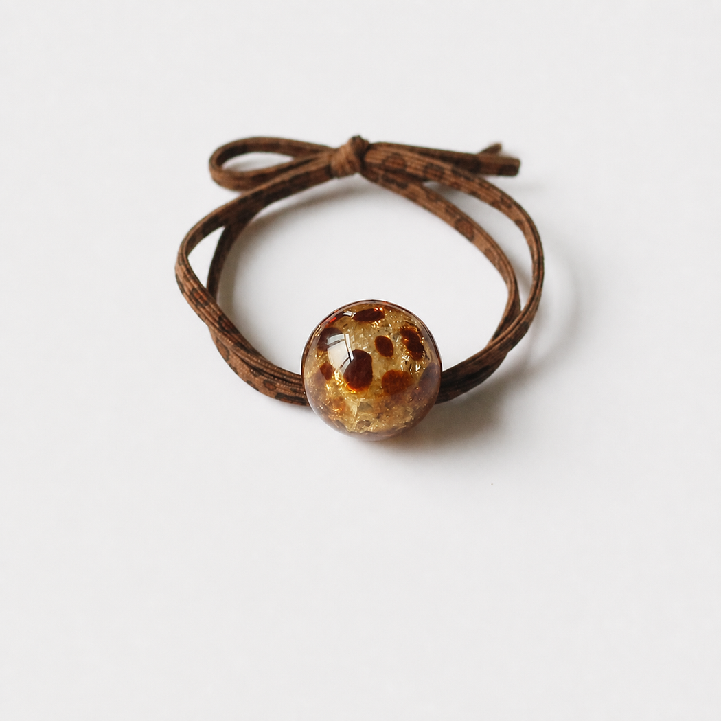 Gold transparent leopard bead hair tie on clean white background