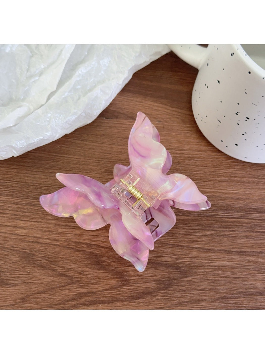 Butterfly claw clip in pastel pink with metal spring mechanism visible