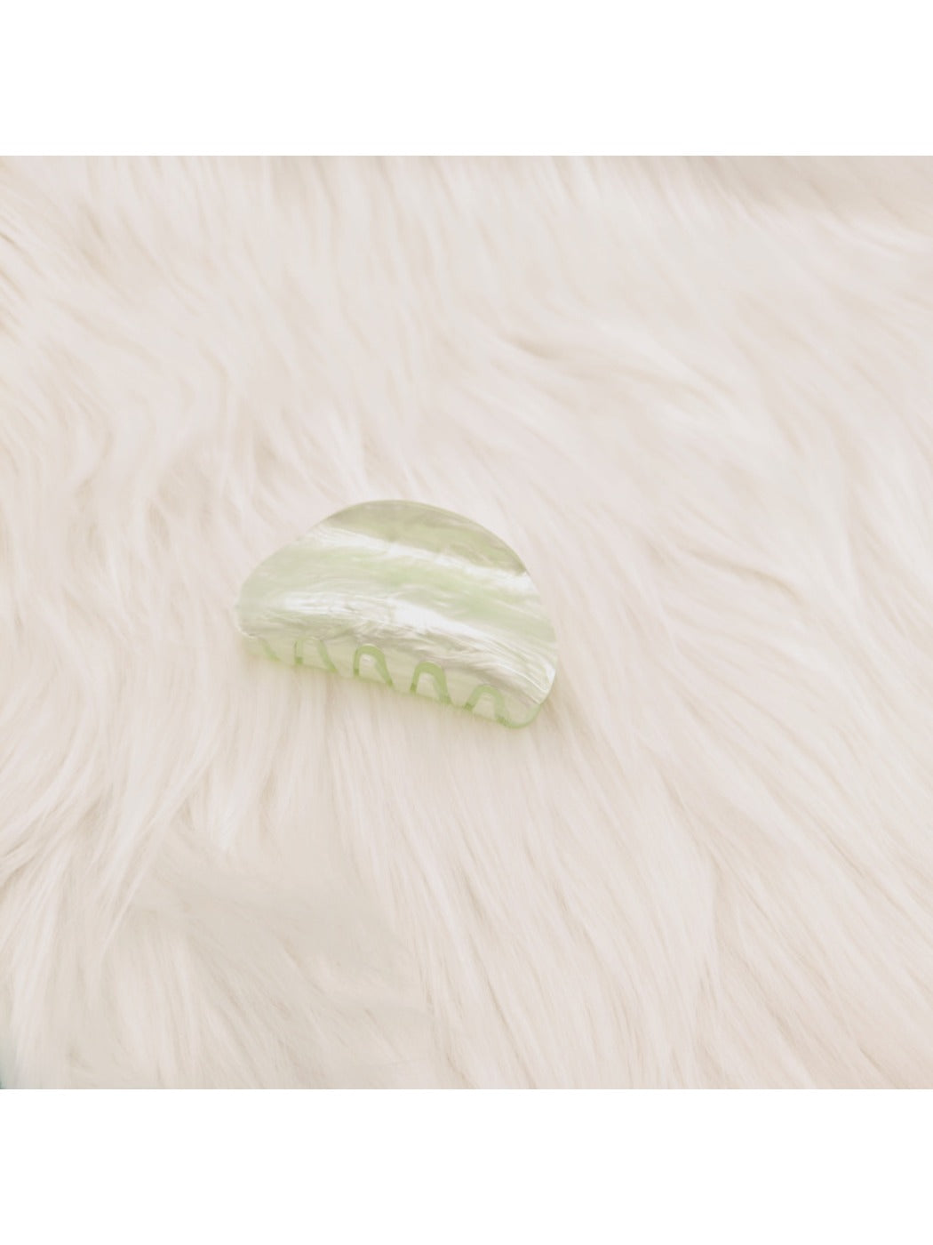Beau claw clip in marble pattern held in hand to show size and detail