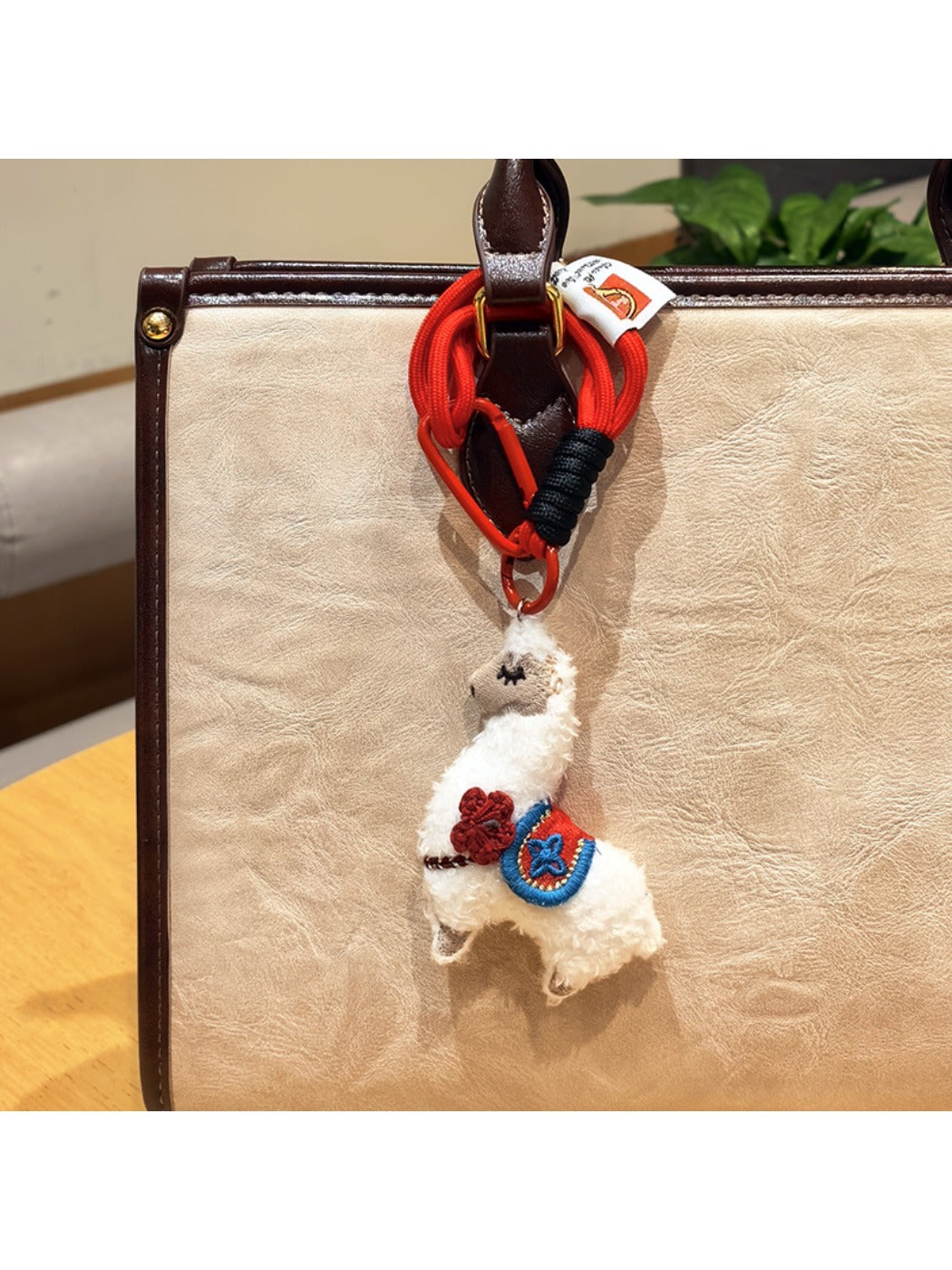Alpaca keychain resting on a notebook with a pen nearby