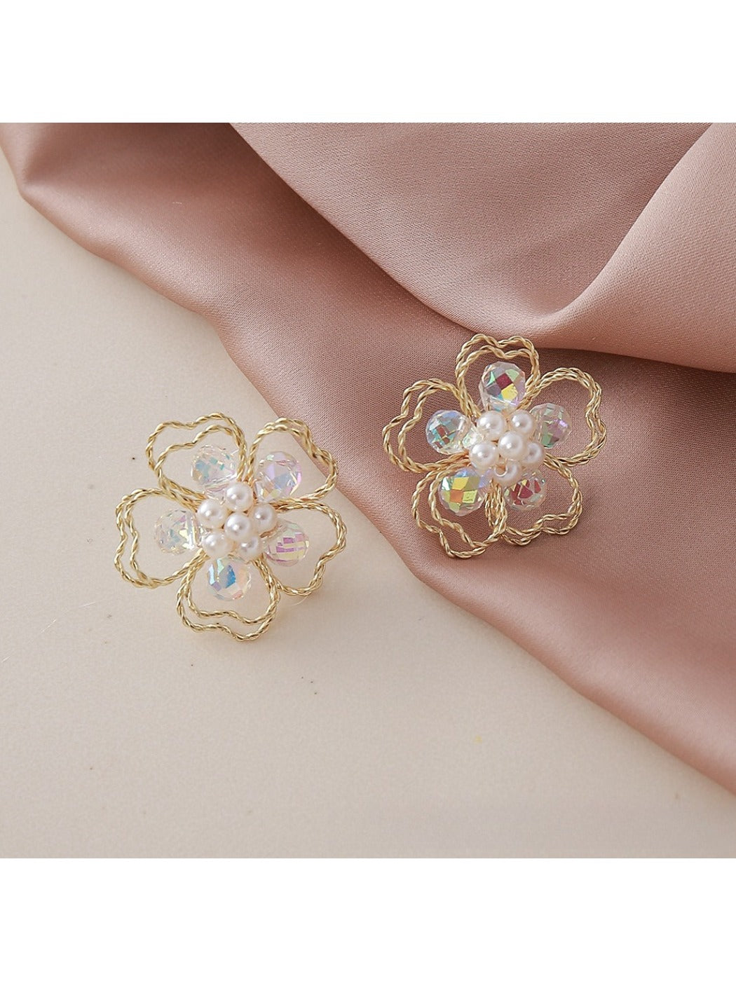 Small beaded flower earrings placed on a wooden surface with natural lighting