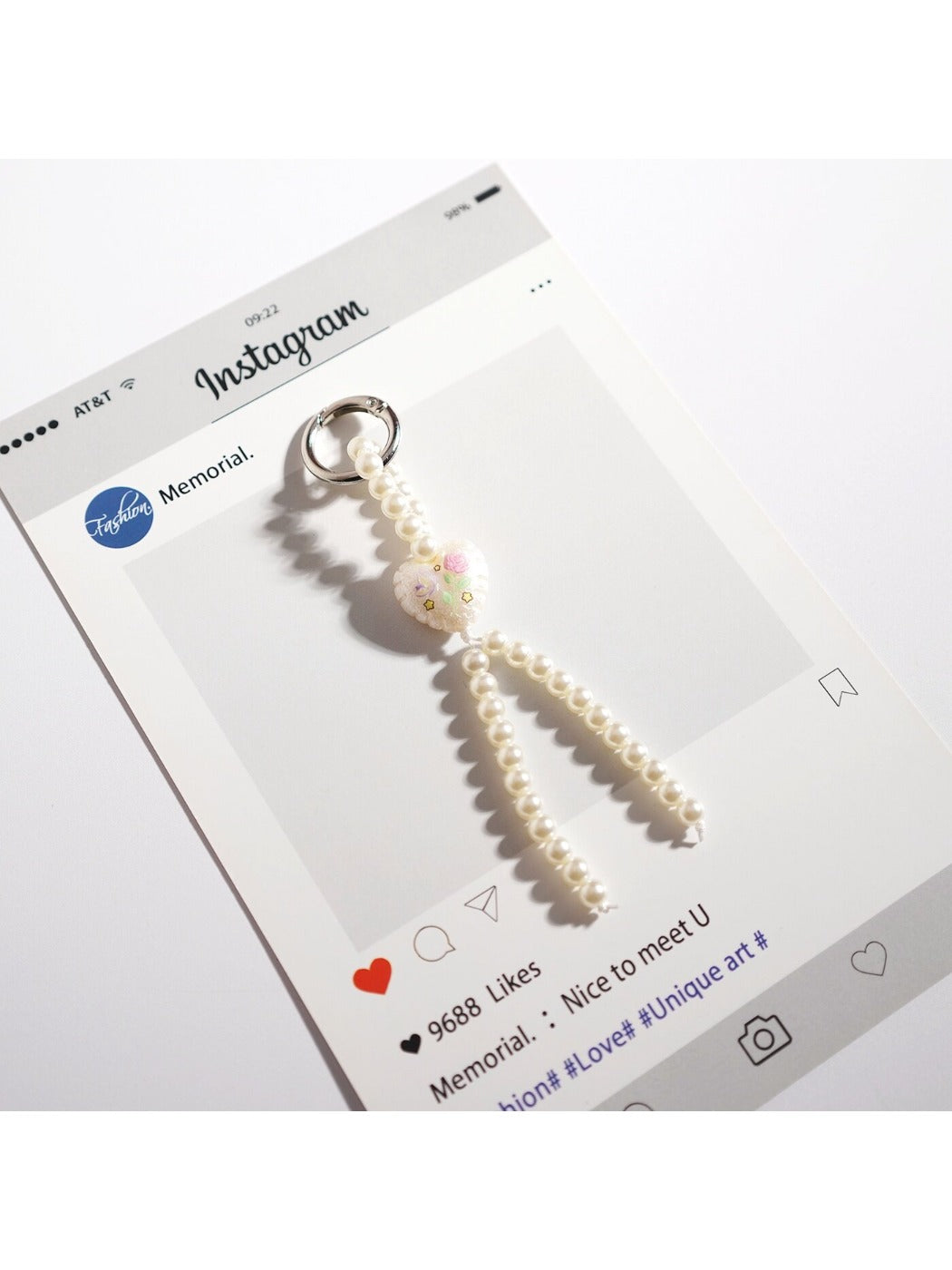 Keypus bow keychain with pink and white beads displayed against a pastel background