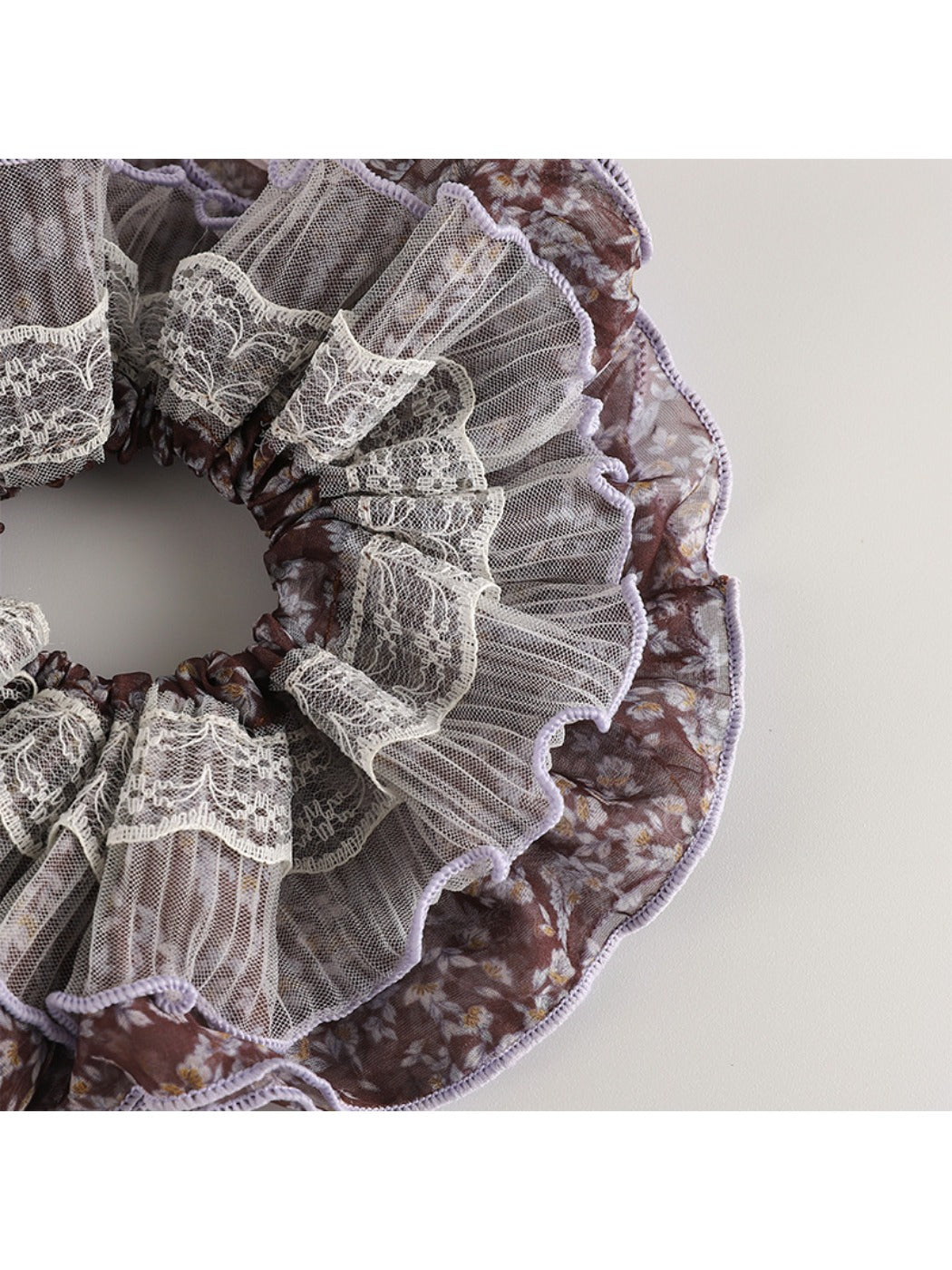 Side view of vintage purple floral scrunchie highlighting gathered fabric texture