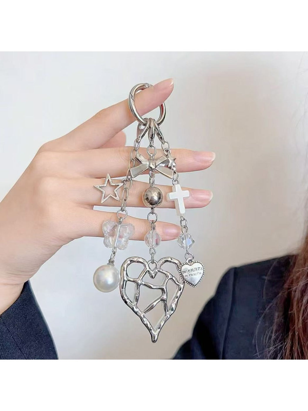 Heart shaped charm keychain attached to a silver keyring with a white backdrop