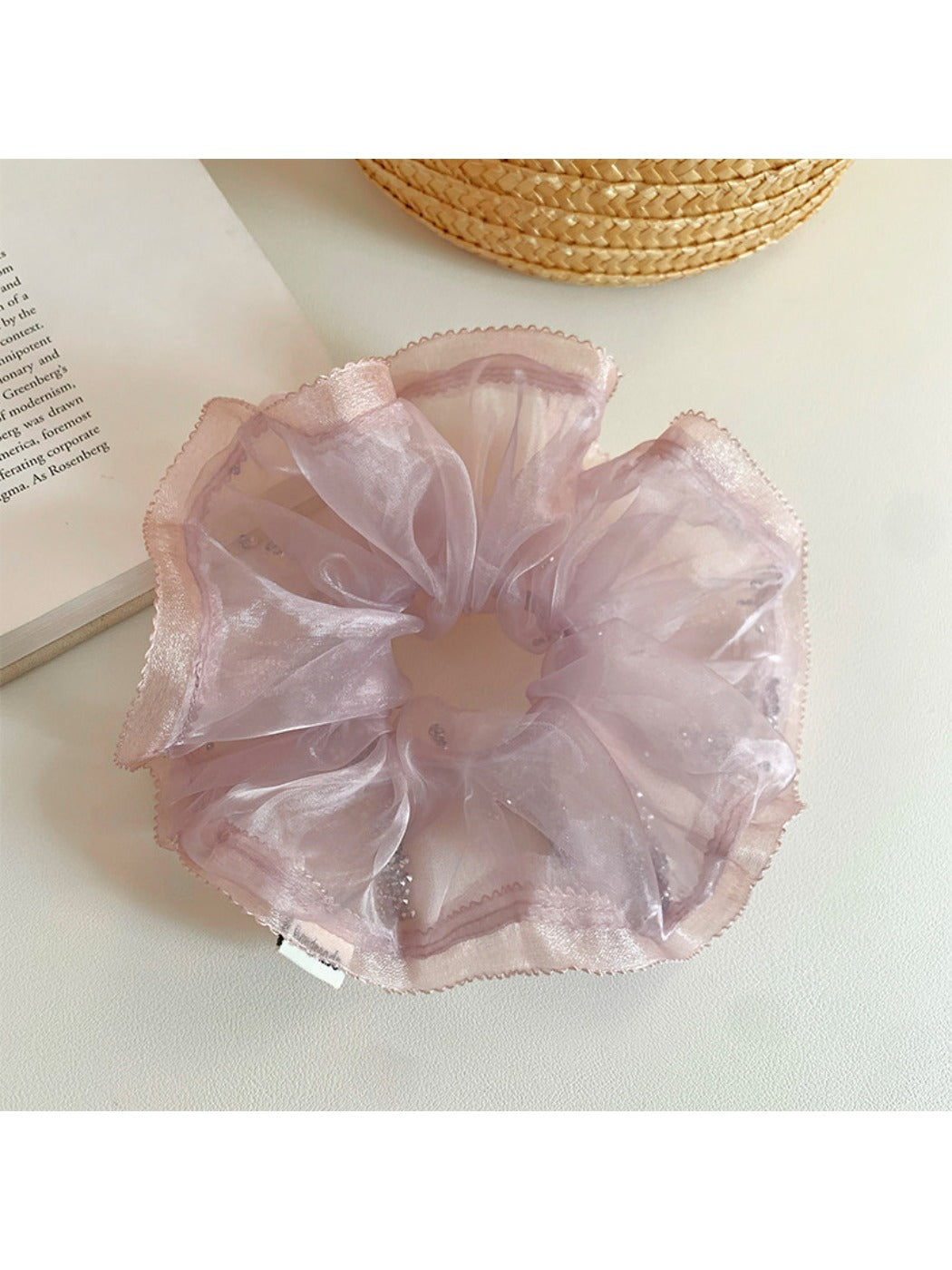 Pink scrunchie with soft ruffles displayed flat to show texture and design
