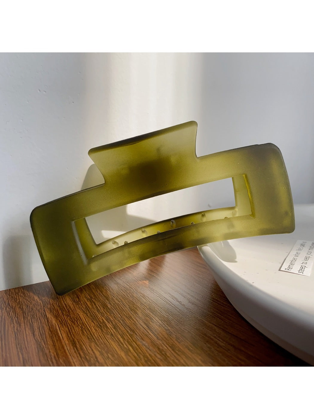 Beau hair claw clip resting on a fabric surface with soft shadows