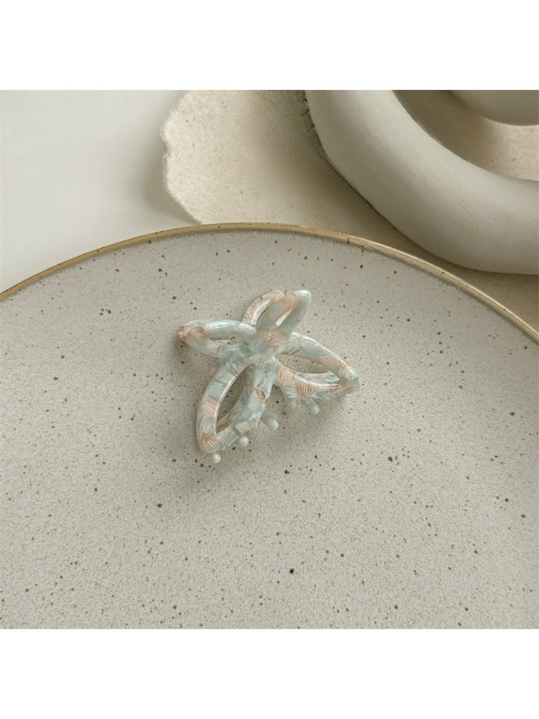 Beau butterfly claw clip in natural light emphasizing translucent acetate colors