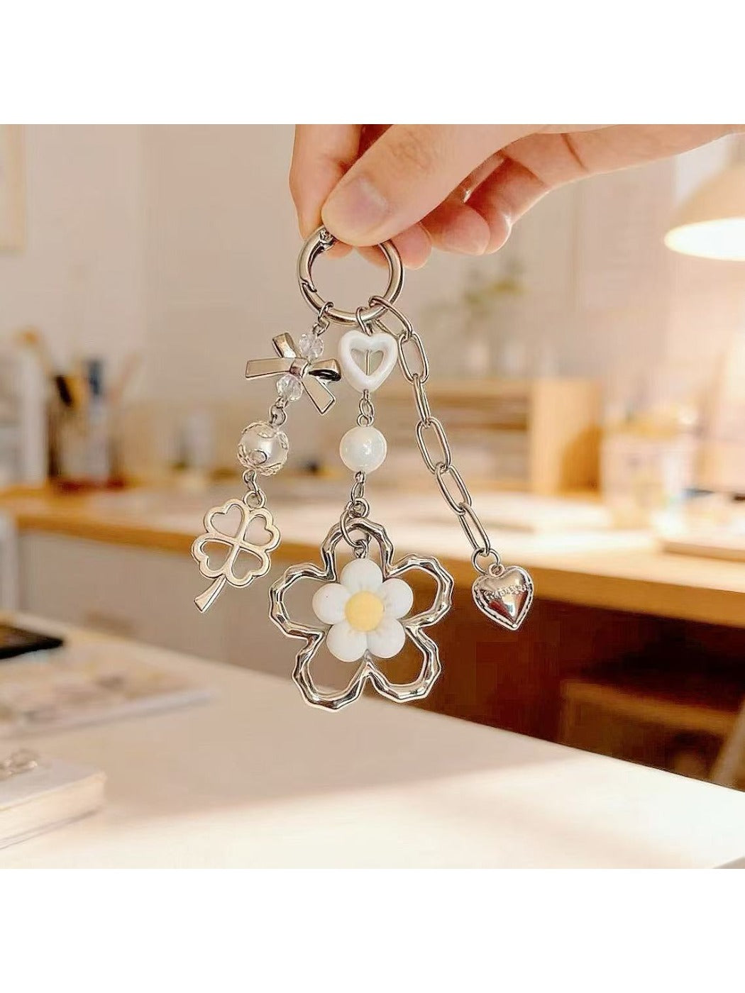 Flower charm keychain hanging from a hand, showcasing its modern minimalist design