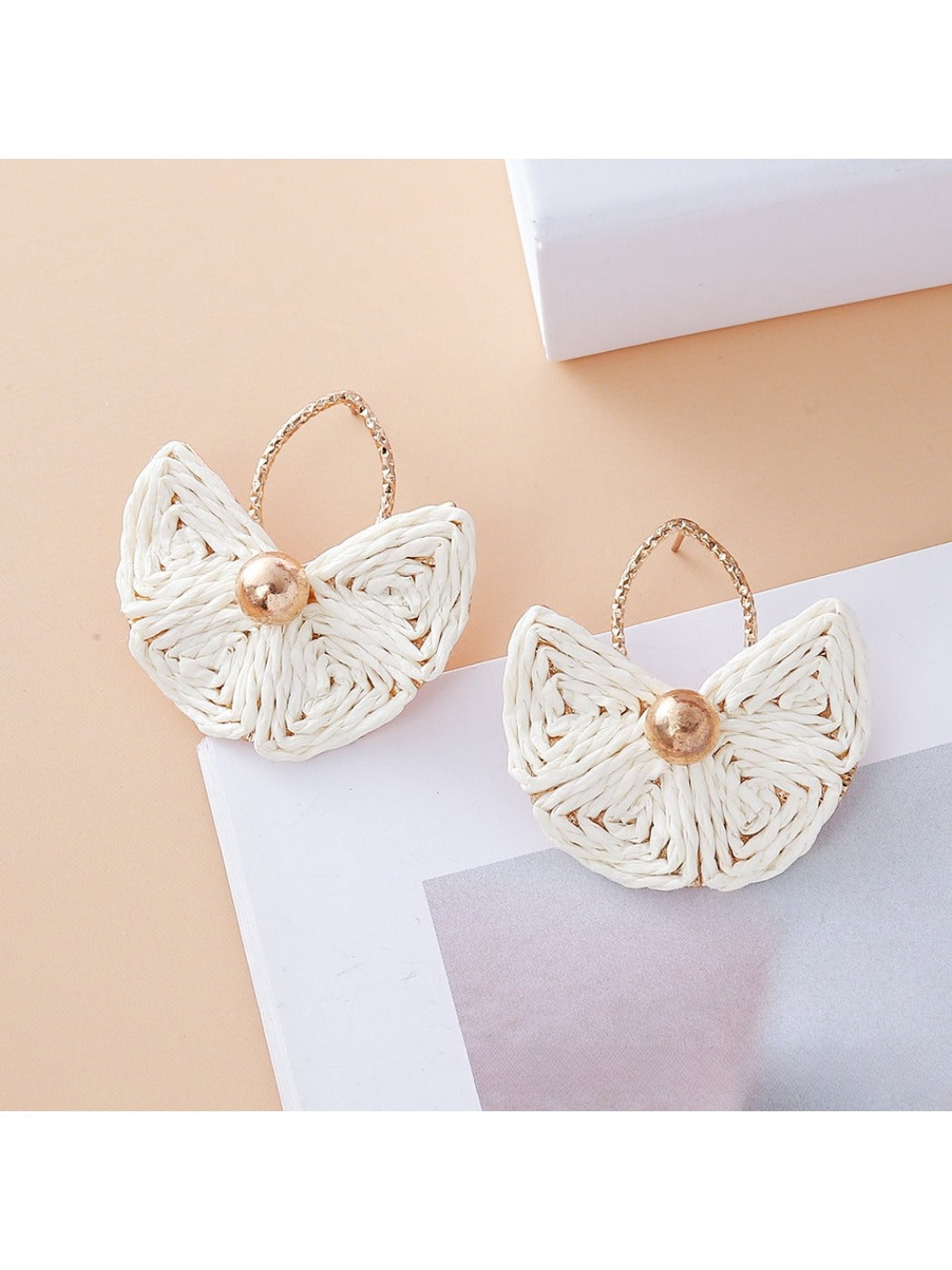 Model profile wearing vintage fan shaped raffia drop earrings with short hair