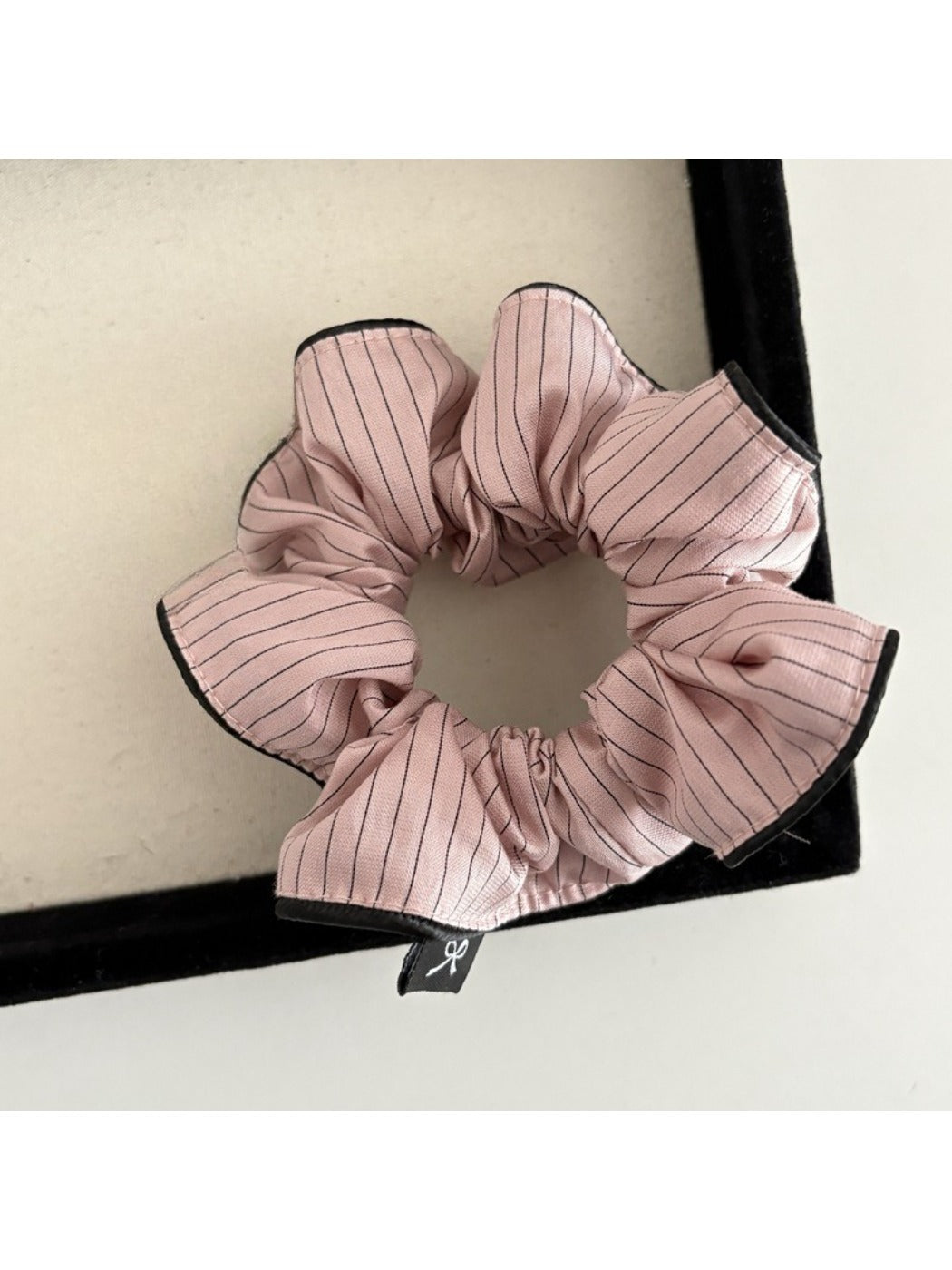 Multiple Gifty striped scrunchies stacked to show variety of colors and stripes