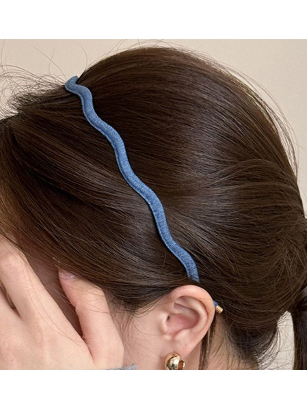 Denim wave headband styled with loose hair on a wooden surface