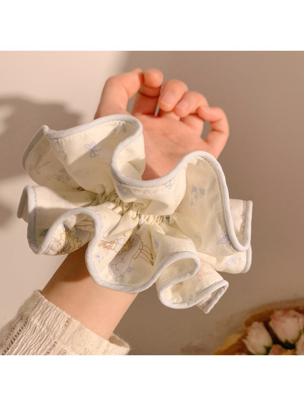 Gifty scrunchie worn on wrist displaying double layer design and cartoon print