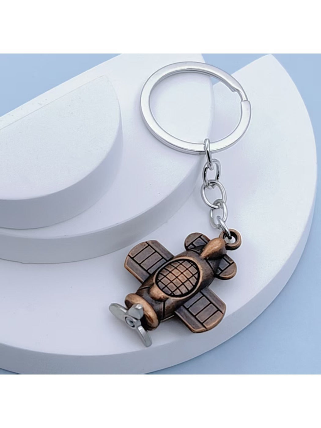Airplane keychain displayed on a white background with shadow
